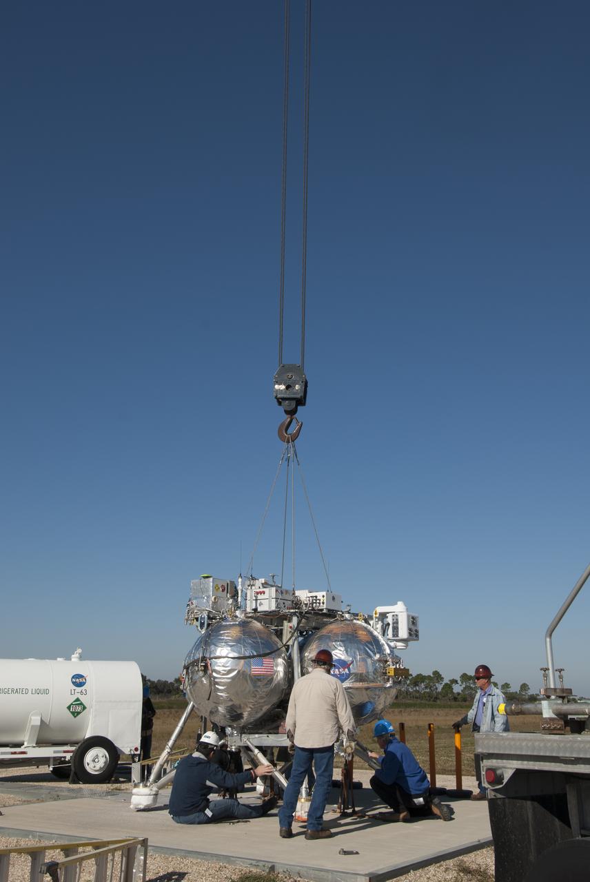 Engineers and technicians prepare NASA's Project Morpheus prototype lander for free flight test number 15 on a launch pad at the north end of the Shuttle Landing Facility at NASA's Kennedy Space Center in Florida. The lander will take off from the ground over a flame trench and use its autonomous landing and hazard avoidance technology, or ALHAT sensors, to survey the hazard field to determine safe landing sites. Project Morpheus tests NASA’s ALHAT and an engine that runs on liquid oxygen and methane, which are green propellants. These new capabilities could be used in future efforts to deliver cargo to planetary surfaces. Project Morpheus is being managed under the Advanced Exploration Systems, or AES, Division in NASA’s Human Exploration and Operations Mission Directorate.