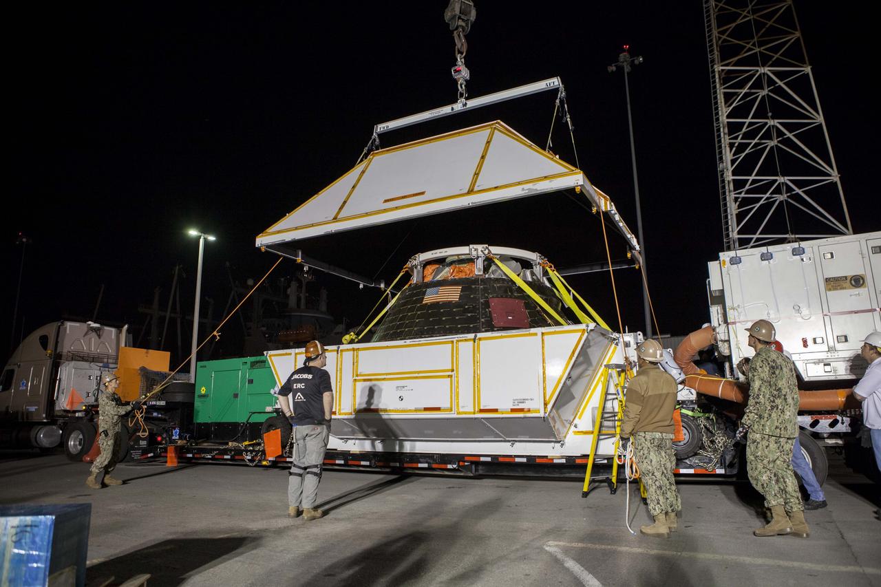 The Orion crew module has been lowered and secured in the crew module transportation fixture at the Mole Pier at Naval Base San Diego in California. The fixture has been secured on the back of a flatbed truck and the cover is being lowered over the spacecraft. Orion is being prepared for the overland trip back to NASA's Kennedy Space Center in Florida. Orion was recovered from the Pacific Ocean after completing a two-orbit, four-and-a-half hour mission Dec. 5 to test systems critical to crew safety, including the launch abort system, the heat shield and the parachute system. NASA, the U.S. Navy and Lockheed Martin coordinated efforts to recover Orion. The Ground Systems Development and Operations Program led the recovery, offload and pre-transportation efforts. 