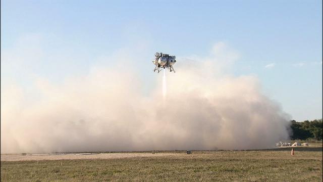 NASA’s Project Morpheus prototype lander rises above a cloud of dust as it takes off on free flight test No. 15 at the north end of the Shuttle Landing Facility at Kennedy Space Center in Florida. During the 97-second test, onboard autonomous landing and hazard avoidance technology sensors, or ALHAT, surveyed the hazard field for safe landing sites, then guided the lander forward and downward to a successful landing.