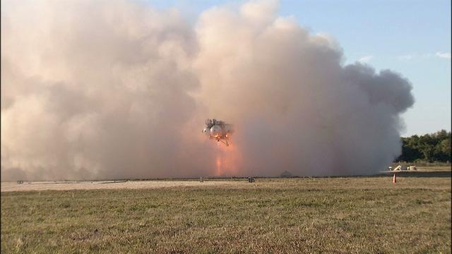 NASA’s Project Morpheus prototype lander is enveloped in a cloud of dust as it takes off on free flight test No. 15 at the north end of the Shuttle Landing Facility at Kennedy Space Center in Florida. During the 97-second test, onboard autonomous landing and hazard avoidance technology sensors, or ALHAT, surveyed the hazard field for safe landing sites, then guided the lander forward and downward to a successful landing.