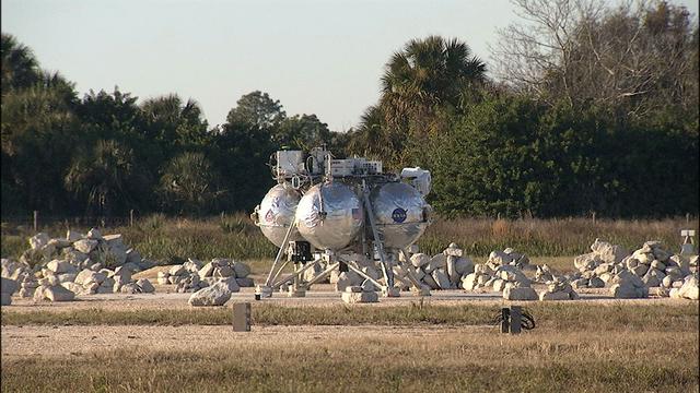 NASA’s Project Morpheus prototype lander comes to rest after a successful landing, capping free flight test No. 15 at the north end of the Shuttle Landing Facility at Kennedy Space Center in Florida. During the 97-second test, onboard autonomous landing and hazard avoidance technology sensors, or ALHAT, surveyed the hazard field for safe landing sites, then guided the lander forward and downward to a successful landing.