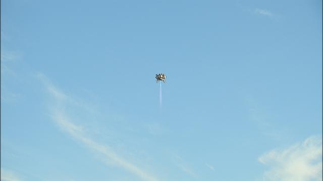 NASA’s Project Morpheus prototype lander soars 800 feet above the north end of the Shuttle Landing Facility at Kennedy Space Center in Florida on free flight test No. 15. During the 97-second test, onboard autonomous landing and hazard avoidance technology sensors, or ALHAT, surveyed the hazard field for safe landing sites, then guided the lander forward and downward to a successful landing. 