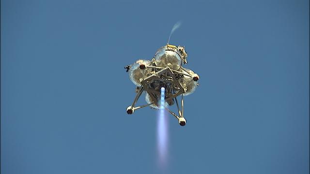 NASA’s Project Morpheus prototype lander soars overhead during free flight test No. 15 at the north end of the Shuttle Landing Facility at Kennedy Space Center in Florida. During the 97-second test, onboard autonomous landing and hazard avoidance technology sensors, or ALHAT, surveyed the hazard field for safe landing sites, then guided the lander forward and downward to a successful landing.