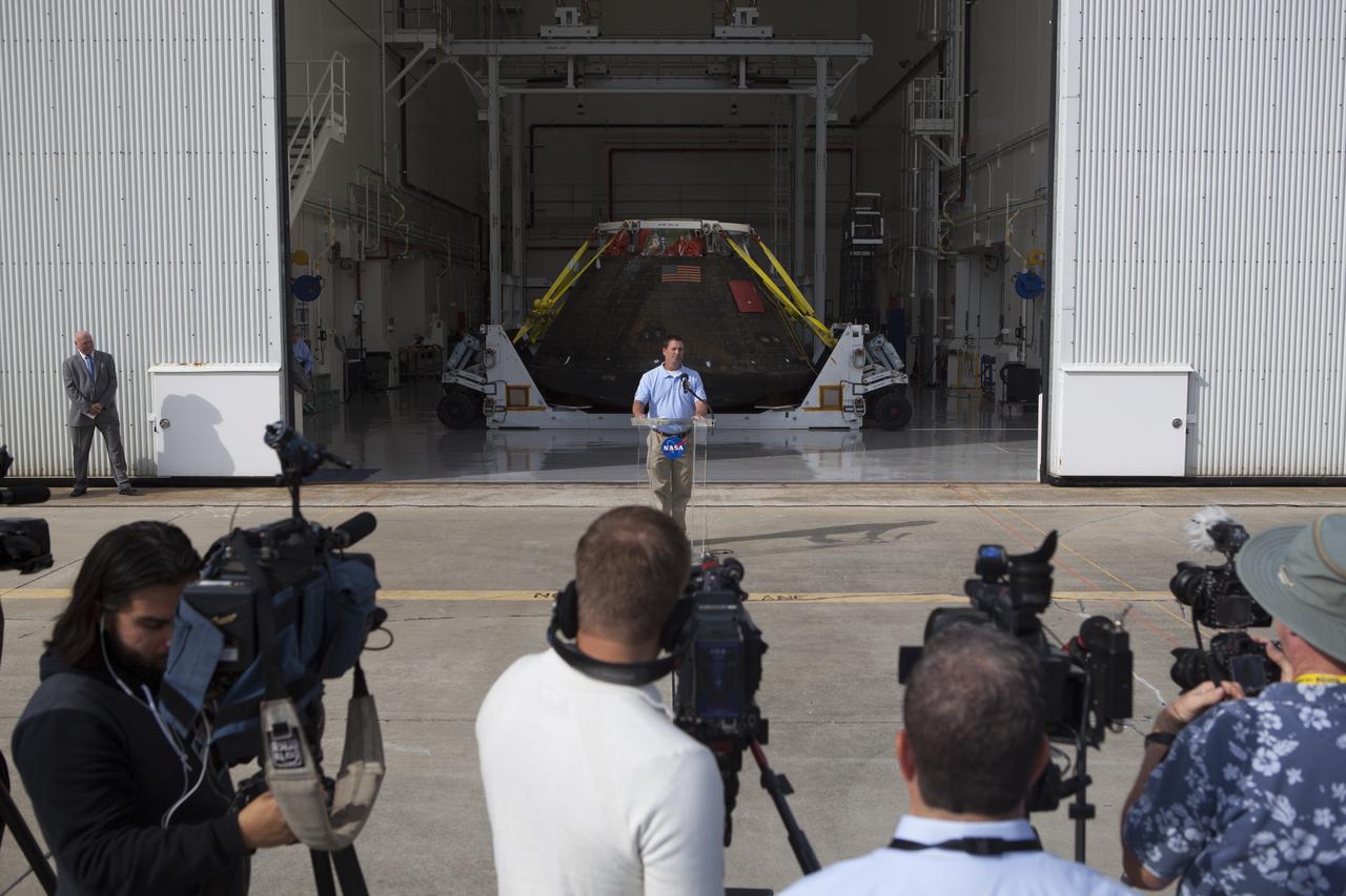 NASA's Orion spacecraft is viewed by members of the media at the Launch Abort System Facility at NASA's Kennedy Space Center in Florida. Lou Garcia, with the Ground Systems Development and Operations Program, or GSDO, speaks to the media during the viewing opportunity. The spacecraft's cross-country return, a 2,700 mile road trip from Naval Base San Diego to Kennedy, sets the stage for in-depth analysis of data obtained during Orion's trip to space. It will provide engineers with detailed information on how the spacecraft fared during its two-orbit, 4.5-hour flight test, completed on Dec. 5. GSDO led the recovery, offload and transportation efforts.