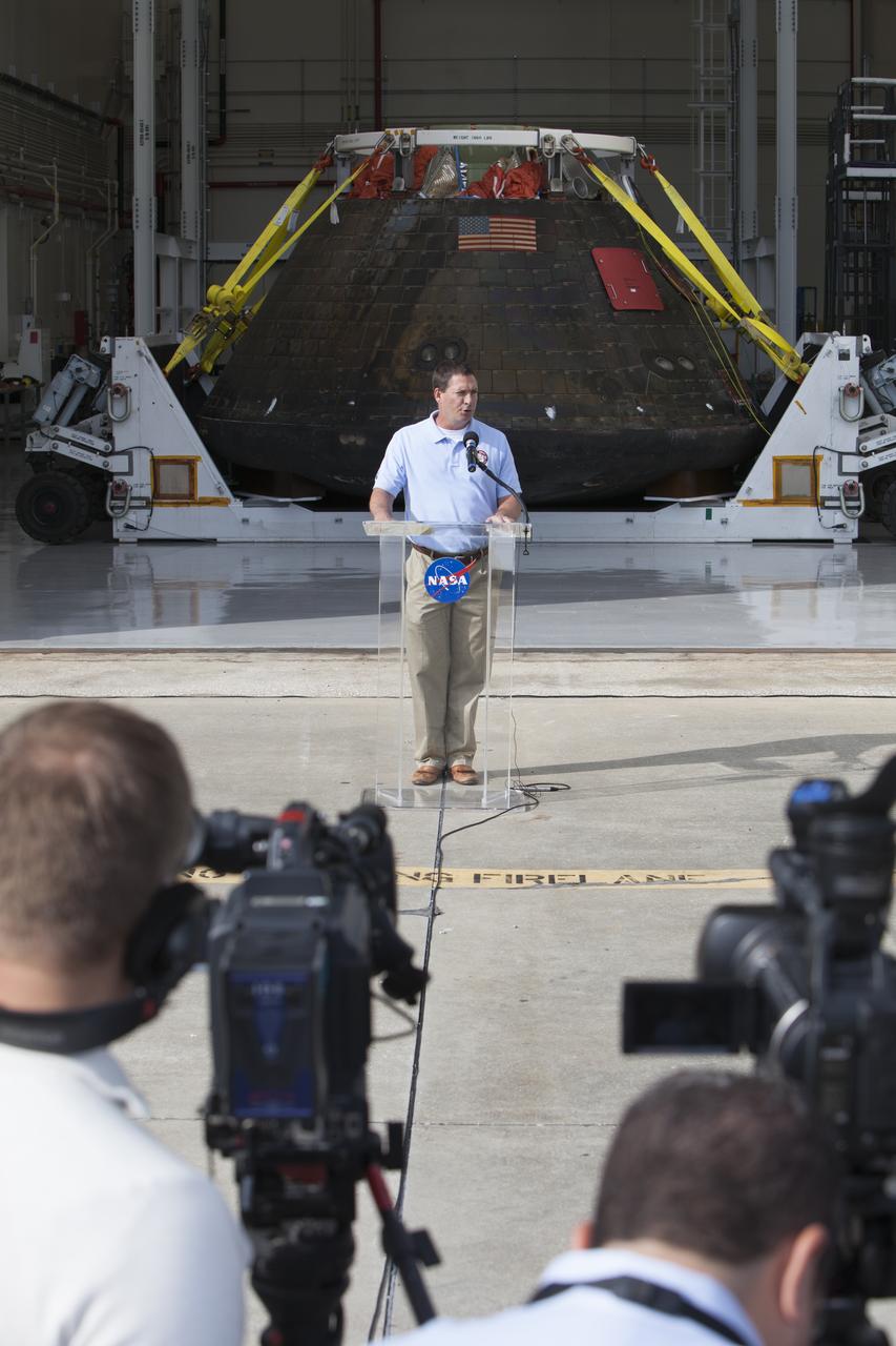 NASA's Orion spacecraft is viewed by members of the media at the Launch Abort System Facility at NASA's Kennedy Space Center in Florida. Lou Garcia, with the Ground Systems Development and Operations Program, or GSDO, speaks to the media during the viewing opportunity. The spacecraft's cross-country return, a 2,700 mile road trip from Naval Base San Diego to Kennedy, sets the stage for in-depth analysis of data obtained during Orion's trip to space. It will provide engineers with detailed information on how the spacecraft fared during its two-orbit, 4.5-hour flight test, completed on Dec. 5. GSDO led the recovery, offload and transportation efforts.