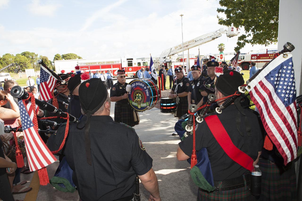 The Brevard Police and Fire Pipe and Drum corps perform during the dedication service for a memorial to the 343 first responder victims of the Sept. 11, 2001, terror attacks at Fire Station 1 at NASA's Kennedy Space Center on Sept. 11, 2015. The ceremony dedicated a monument that includes a section of steel I-beam from the World Trade Center in New York. 