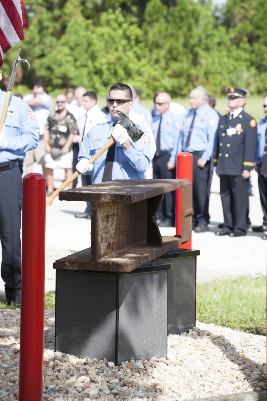 A memorial to the 343 first responder victims of the Sept. 11, 2001, terror attacks stands at Fire Station 1 at NASA's Kennedy Space Center during its dedication on Sept. 11, 2015. A section of steel I-beam from the World Trade Center in New York forms the centerpiece of the monument.