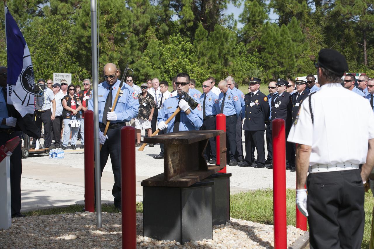 Firefighters stand at attention as a memorial to the 343 first responder victims of the Sept. 11, 2001, terror attacks is dedicated at Fire Station 1 at NASA's Kennedy Space Center on Sept. 11, 2015. A section of steel I-beam from the World Trade Center in New York forms the centerpiece of the monument.