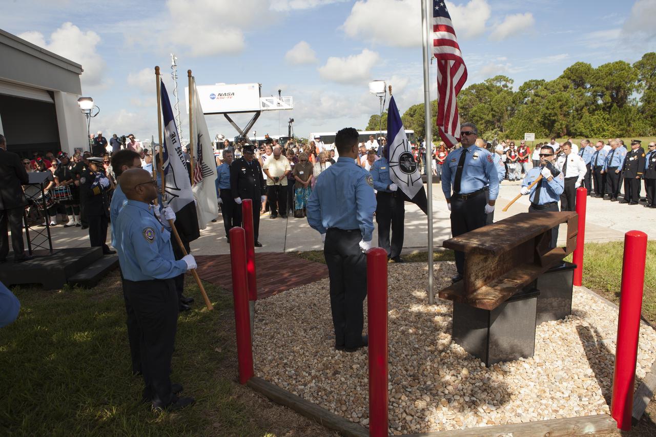 Firefighters stand at attention as a memorial to the 343 first responder victims of the Sept. 11, 2001, terror attacks is dedicated at Fire Station 1 at NASA's Kennedy Space Center on Sept. 11, 2015. A section of steel I-beam from the World Trade Center in New York forms the centerpiece of the monument. 