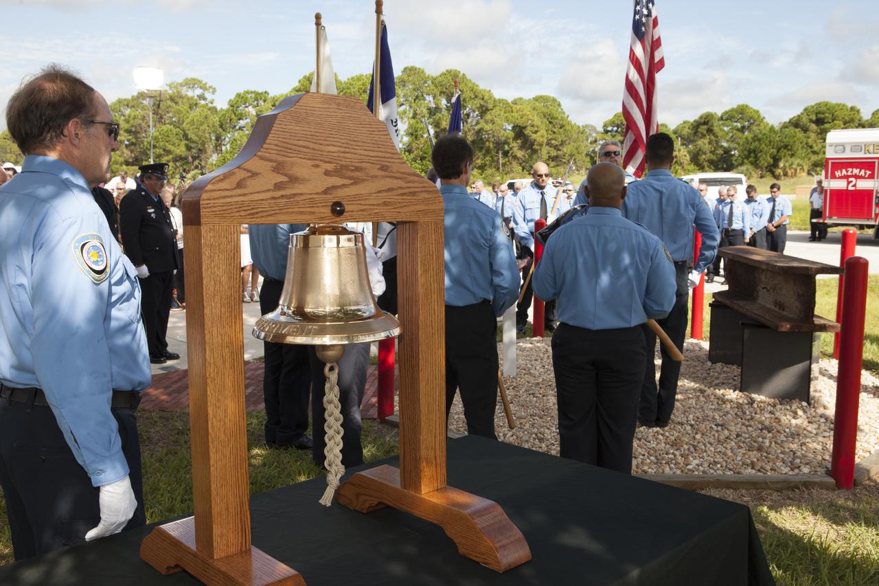 Firefighters stand at attention as a memorial to the 343 first responder victims of the Sept. 11, 2001, terror attacks is dedicated at Fire Station 1 at NASA's Kennedy Space Center on Sept. 11, 2015. A section of steel I-beam from the World Trade Center in New York forms the centerpiece of the monument.