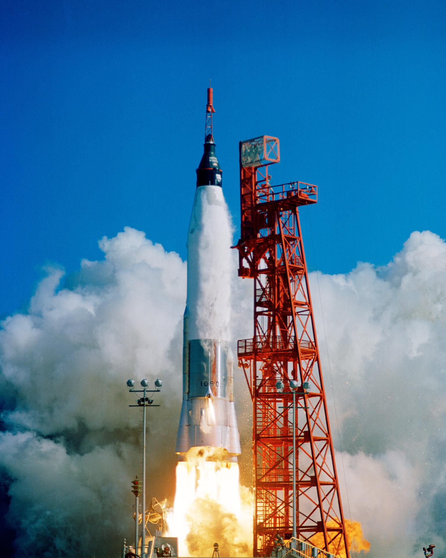 The Friendship 7 spacecraft launches from Pad 14 at Cape Canaveral on the Atlas rocket with a huge plume of exhaust clouds.