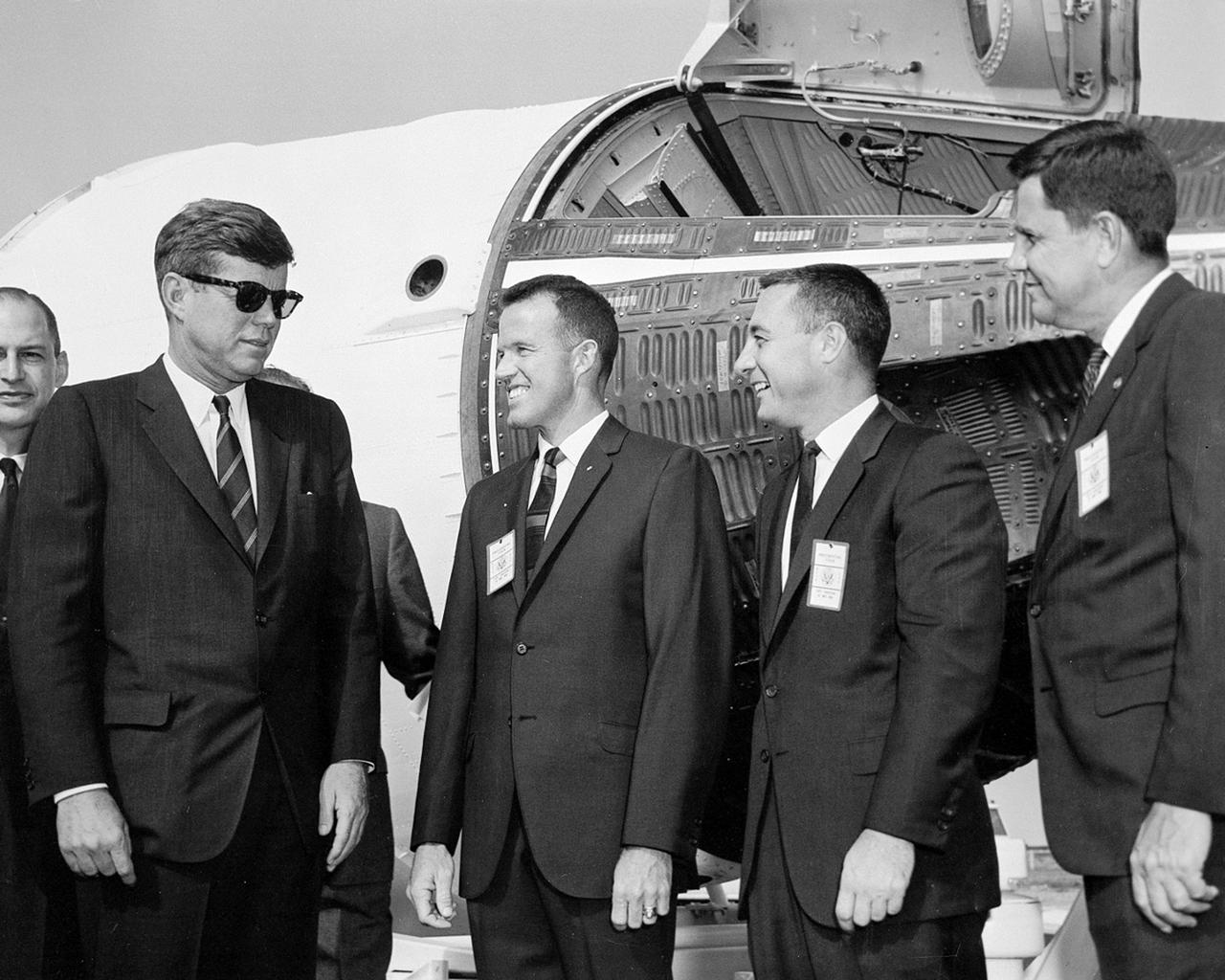 CAPE CANAVERAL Fla. -- President John F. Kennedy tours the Cape Canaveral Missile Test Annex in Florida. Standing in front of a Gemini spacecraft, from the left, are George M. Low, NASA chief of Manned Space Flight partially visible, Kennedy, astronaut L. Gordon Cooper, astronaut Virgil I. Grissom and G. Merritt Preston, NASA's manager of the Atlantic Missile Range. Photo Credit: NASA
