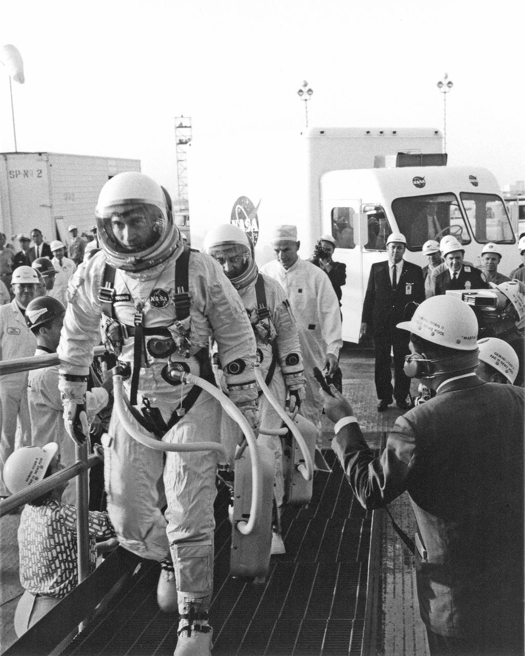 CAPE KENNEDY, Fla. -- At Cape Kennedy Air Force Station in Florida, Gemini 3 pilot John W. Young is followed by command pilot Virgil I. Grissom as they walk to elevator at Launch Complex 19 for their three orbit flight, the first mission of the Gemini spacecraft. Photo Credit: NASA