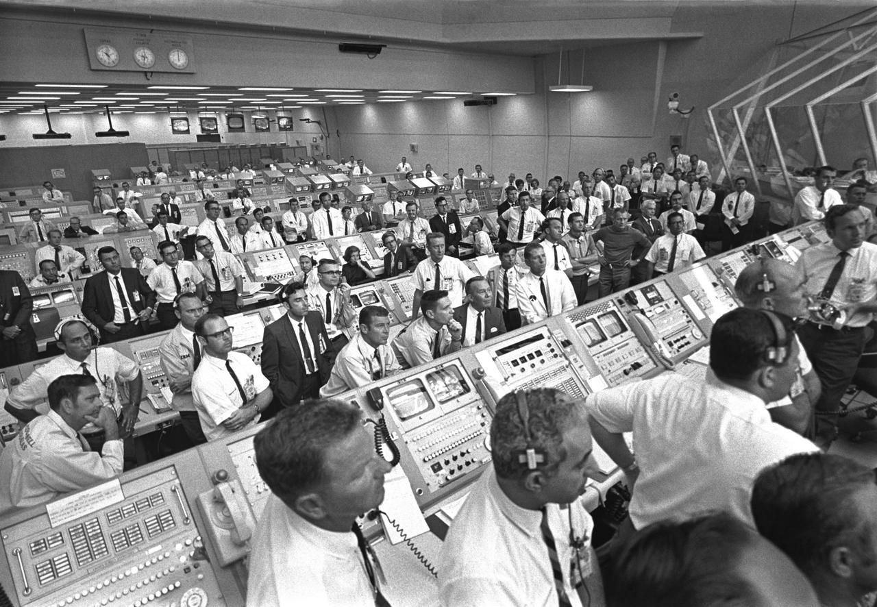 CAPE CANAVERAL, Fla. – Members of the Kennedy Space Center government-industry team rise from their consoles in the Launch Control Center to listen to Vice President Spiro Agnew’s remarks following the Apollo 11 liftoff. Photo credit: NASA