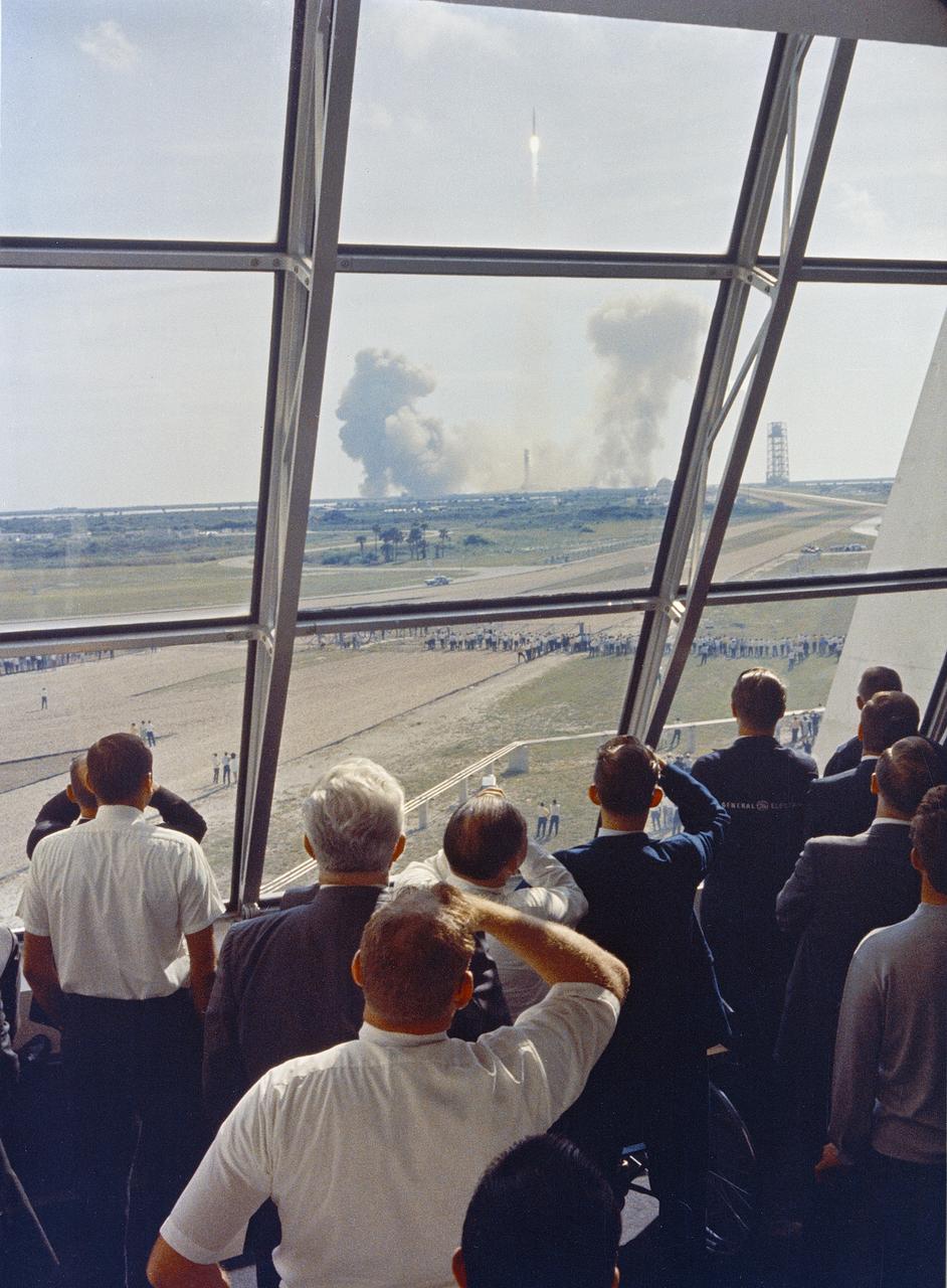 Personnel within the Launch Control Center watch the Apollo 11 liftoff from Launch Complex 39A today at the start of the historic lunar landing mission. The LCC is located three and one-half miles from the launch pad.