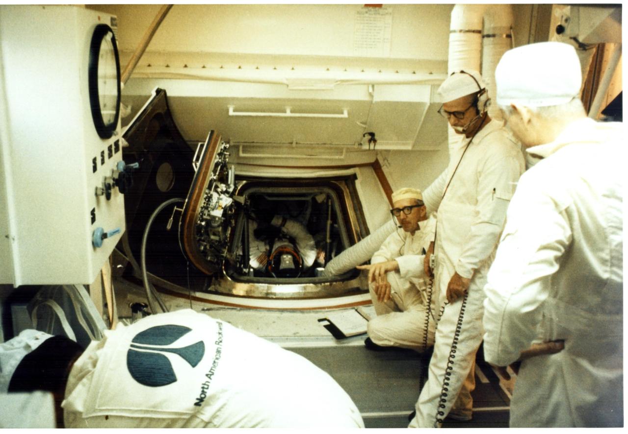KENNEDY SPACE CENTER, FLA. - Pad Leader Guenter Wendt, kneeling, supervises preparations to remove the Apollo 11 astronauts from their spacecraft following the Countdown Demonstration Test, a dress rehearsal prior to the actual launch day. Visible in the hatchway is Command Module Pilot Michael Collins. To his left is Apollo 11 Commander Neil A. Armstrong. At Collins' right is Lunar Module Pilot Edwin E. Aldrin Jr.