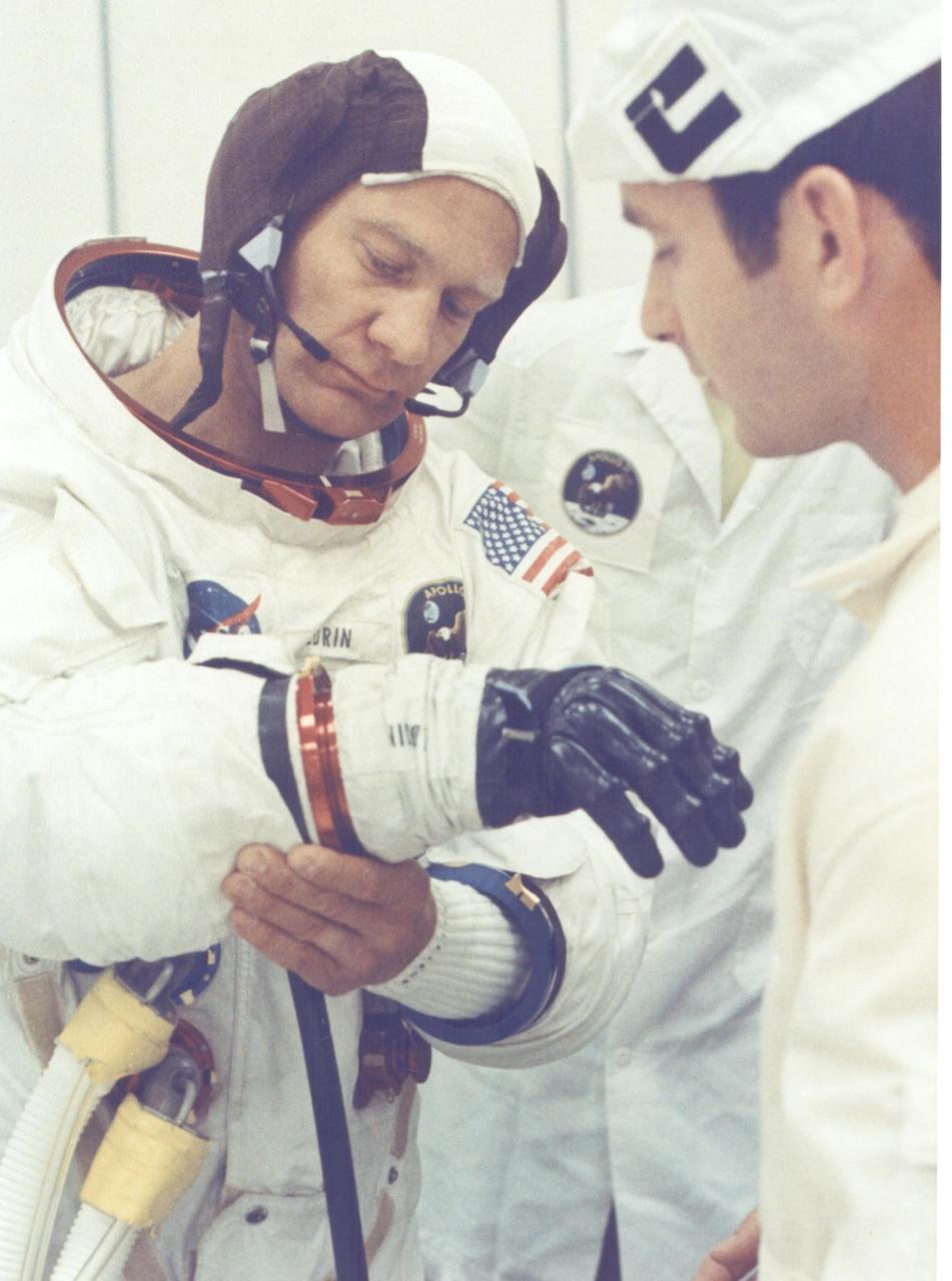 KENNEDY SPACE CENTER, FLA. - Apollo 11 astronaut Edwin E. Aldrin Jr. is being assisted by a spacesuit technician during suiting operations in the Manned Spacecraft Operations Building prior to the astronauts' departure to Launch Pad 39A.  The three astronauts, Edwin E. Aldrin Jr., Neil A Armstrong and Michael Collins, will then board the Saturn V launch vehicle, scheduled for a 9:32 a.m. EDT liftoff for the first manned lunar landing mission.