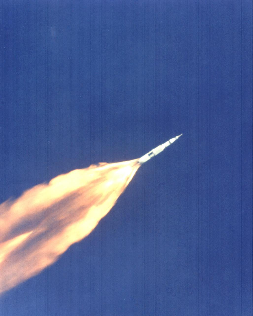 KENNEDY SPACE CENTER, FLA. - The Apollo 11 Saturn V space vehicle climbs toward orbit after liftoff from Pad 39A at 9:32 a.m. EDT. In two-and-a-half minutes of powered flight, the S-IC booster lifts the vehicle to an altitude of about 39 miles approximately 55 miles downrange. This photo was taken with a 70-mm telescopic camera mounted in an Air force EC-135N plane. Onboard are astronauts Neil A. Armstrong, Michael Collins and Edwin E. Aldrin Jr. During the planned eight-day mission, Armstrong and Aldrin will descend in a Lunar Module (LM) to the Moon's surface while Collins orbits overhead in the Command Module. The two astronauts are to spend 22 hours on the Moon, including two-and-one-half hours outside the LM. They will gather samples of lunar material and will deploy scientific experiments that will transmit data about the lunar environment. They will rejoin Collins in the Command Module for the return trip to Earth.
