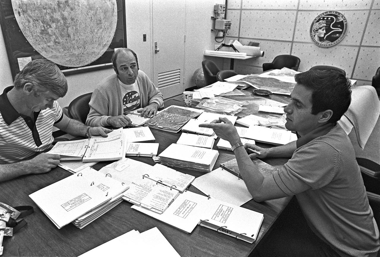 Apollo 17 Astronaut-Scientist Harrison H. Schmitt, right, reviews lunar flight plan with Mission Commander Eugene A. Cernan, left and Command Module Pilot Ronald H. Evans.