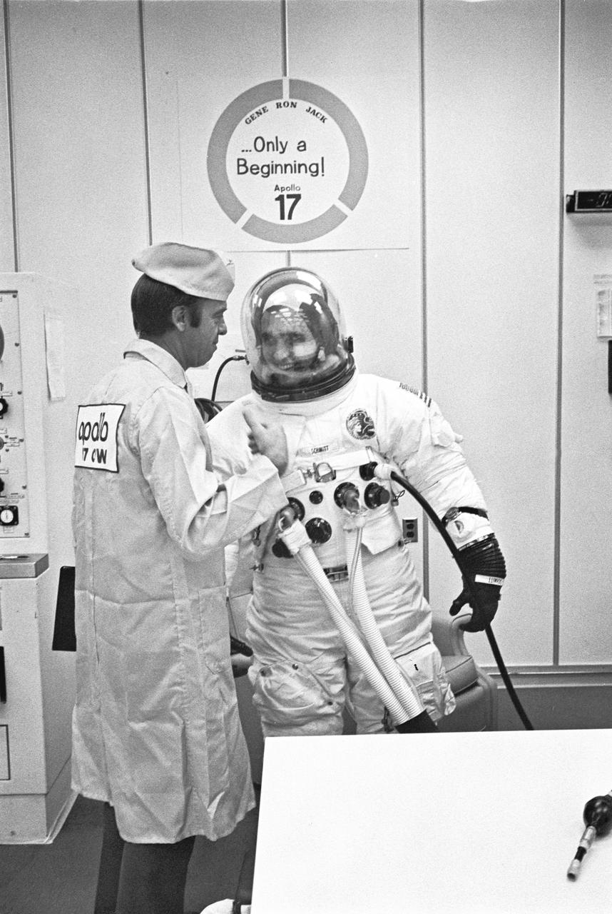 Apollo 17 Lunar module Pilot Harrison H. Schmitt shares a moment of relaxation with astronaut Alan Shepard during prelaunch suiting operations.