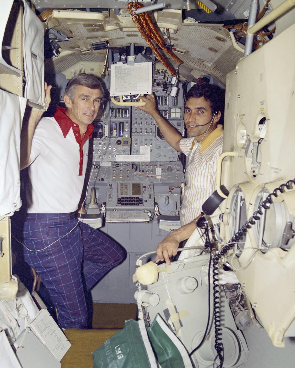 Apollo 17 Mission Commander Eugene A Cernan, a Navy Captain, and Lunar Module Pilot Dr. Harrison H. Schmitt, civilian scientist-astronaut, at right, familiarize themselves with equipment used in the Lunar Module in which they will descend to the lunar surface during December.  Cernan and Dr. Schmitt are undergoing pre-launch training in the lunar Module Simulator at the Flight Crew Training Building at the Space Center.  Navy Commander Ronald E. Evans, Command Module Pilot, will accompany Cernan and Schmitt on the mission.