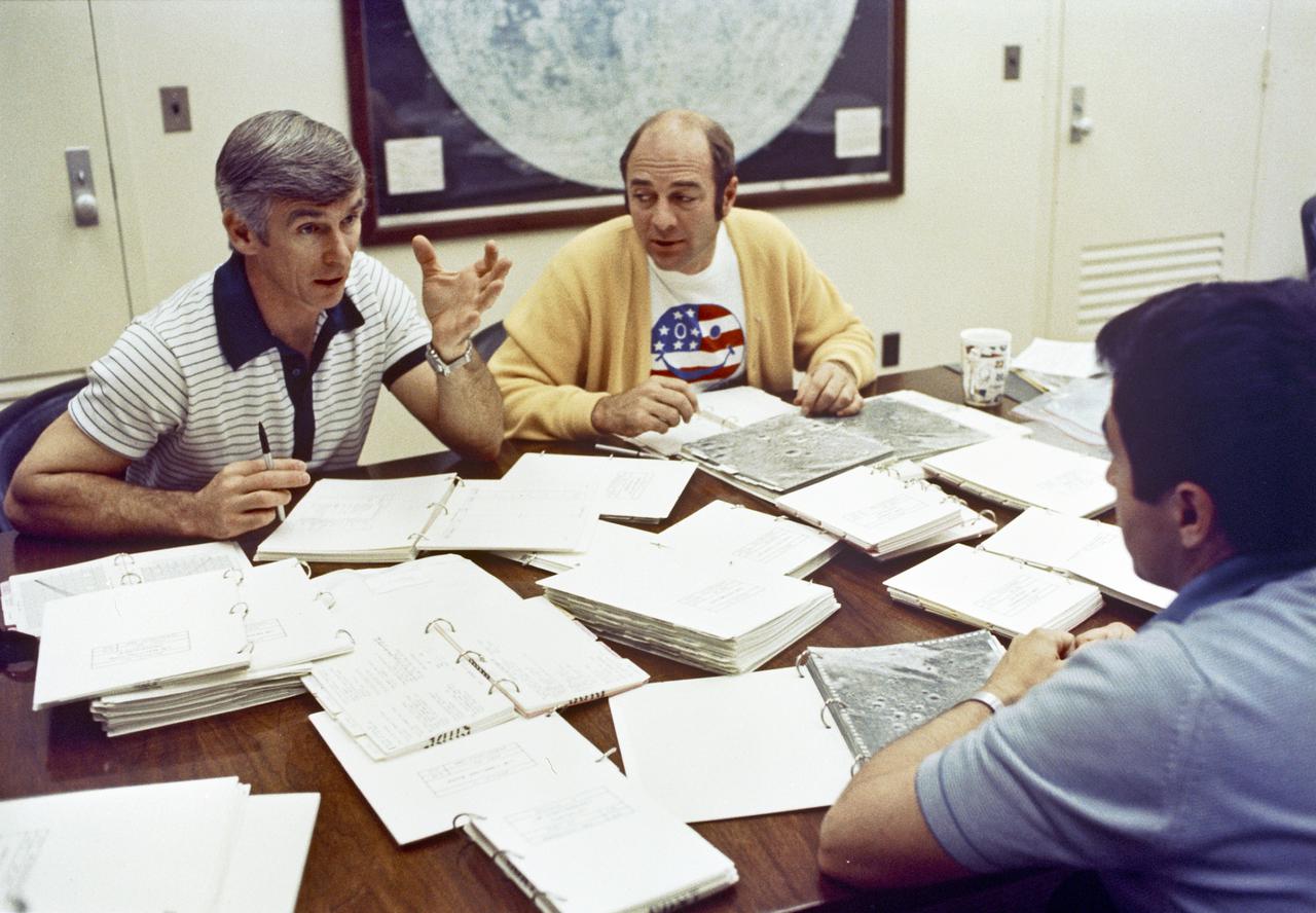 Apollo 17 Mission commander Eugene A. Cernan, left, reviews flight plan with crewmates Ronald E. Evans, center, and Harrison H. Schmitt in the astronaut's quarters.  Evans will pilot the command module alone in lunar orbit while Cernan and Lunar Module Pilot Schmitt explore the Taurus-Littrow region of the Moon's surface.  The launch of Apollo 17 is scheduled for December 6, 1972 at 9:53 p.m.
