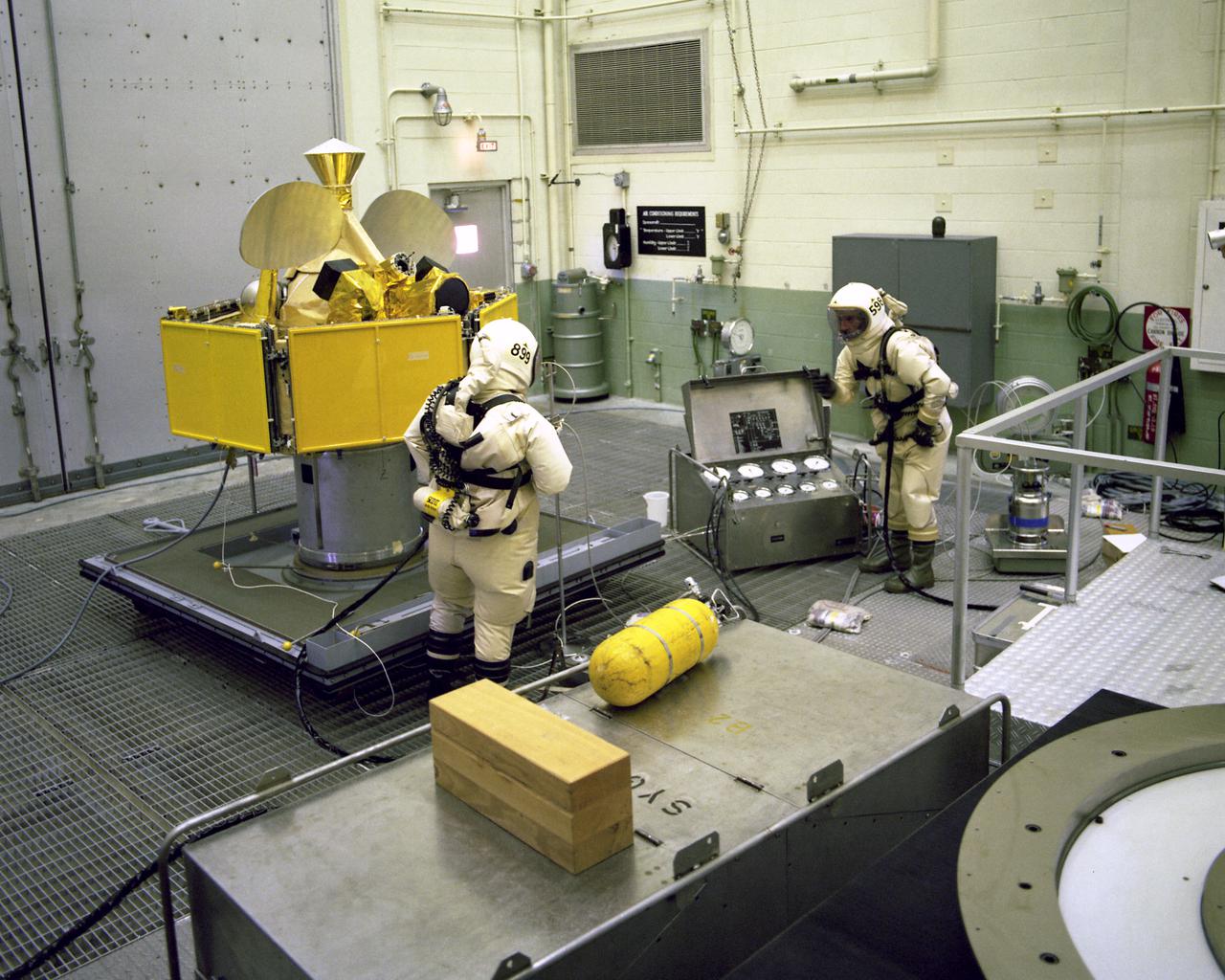 CAPE CANAVERAL, Fla. -- Technicians in protective suits loaded the Symphonie-B spacecraft with propellants in the Spin Test Facility at Cape Canaveral Air Force Station today. The French-West German experimental communications satellite is to be launched by KSC's Unmanned Launch Operations Directorate aboard a Delta rocket from Complex 17 in late August or early September. The satellite will be placed in a synchronous orbit 22,300 miles above the equator south of the West African 'Bulge,' joining Symphonie-1 in handling communications between ground stations in Europe, South America, portions of North America and the Mideast.  Photo credit: NASA                    Photo credit: NASA