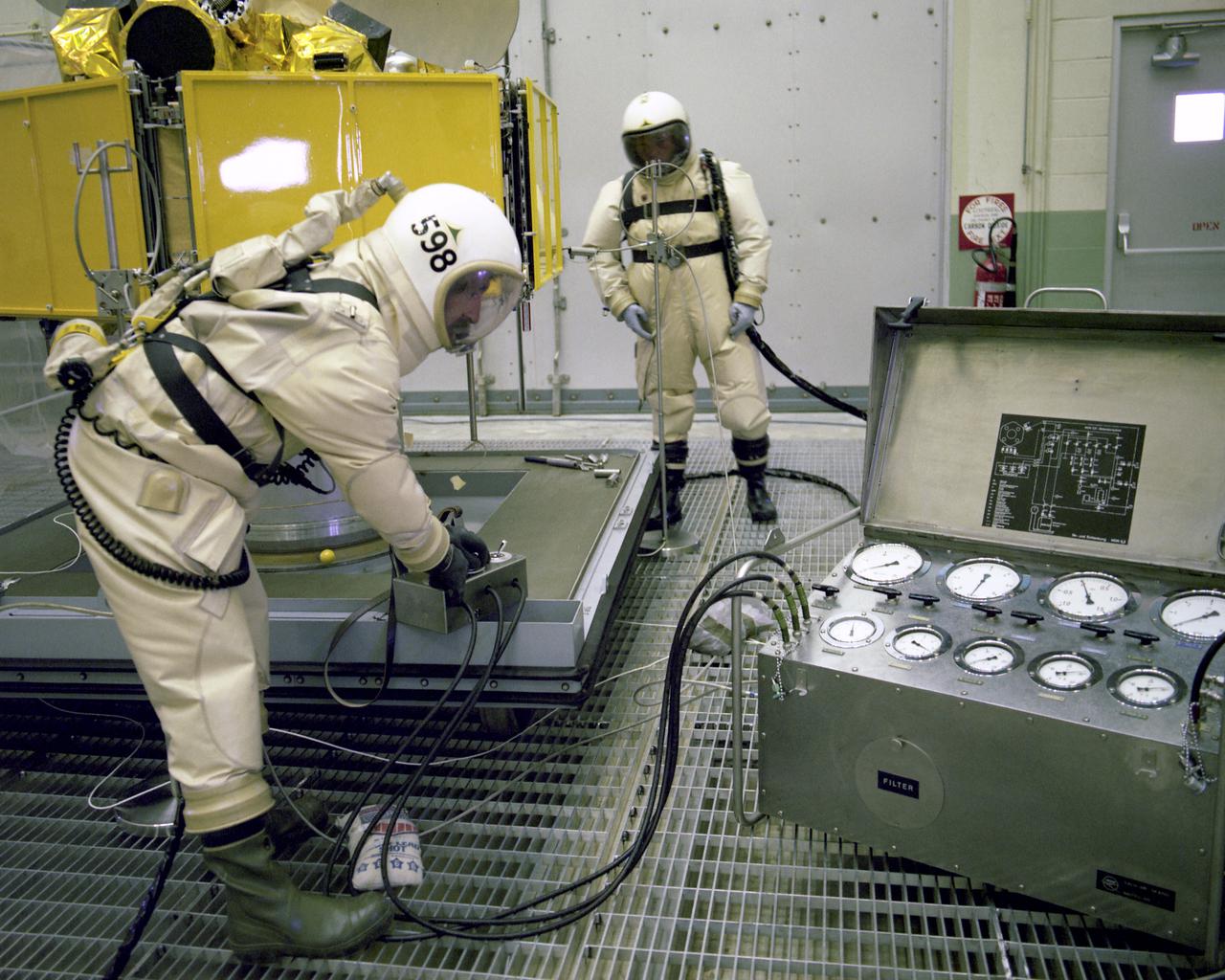 CAPE CANAVERAL, Fla. -- Technicians in protective suits loaded the Symphonie-B spacecraft with propellants in the Spin Test Facility at Cape Canaveral Air Force Station today. The French-West German experimental communications satellite is to be launched by KSC's Unmanned Launch Operations Directorate aboard a Delta rocket from Complex 17 in late August or early September. The satellite will be placed in a synchronous orbit 22,300 miles above the equator south of the West African 'Bulge,' joining Symphonie-1 in handling communications between ground stations in Europe, South America, portions of North America and the Mideast.  Photo credit: NASA                    Photo credit: NASA