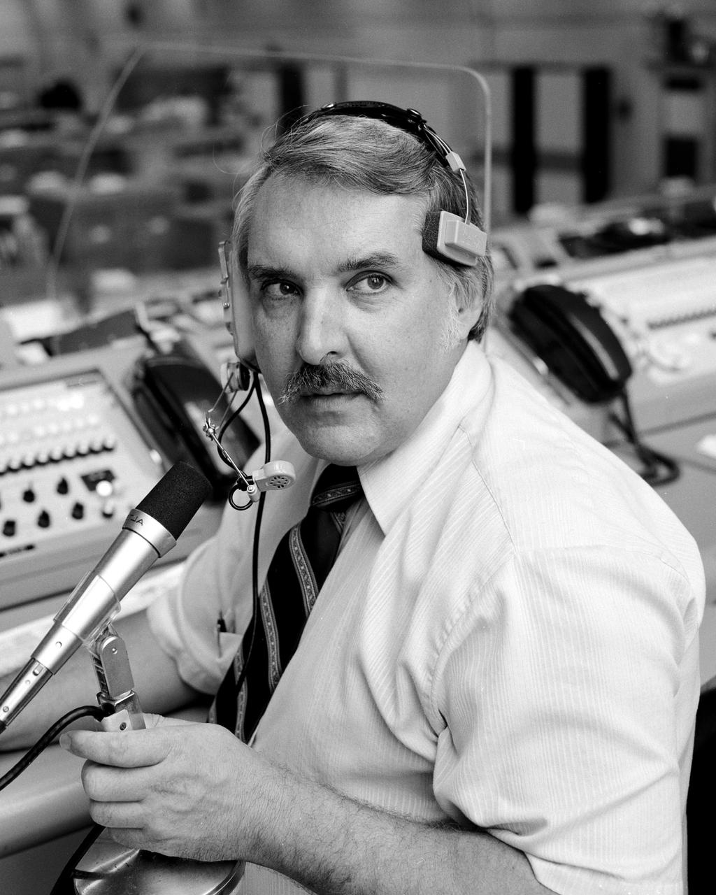 CAPE CANAVERAL, Fla. -- Pictured at his console in the firing room of the Launch Control Center, Complex 39, Hugh Harris, head of the Public Information Branch, Office of Public Affairs, provides the mission commentary for space shuttle launches. Photo credit: NASA