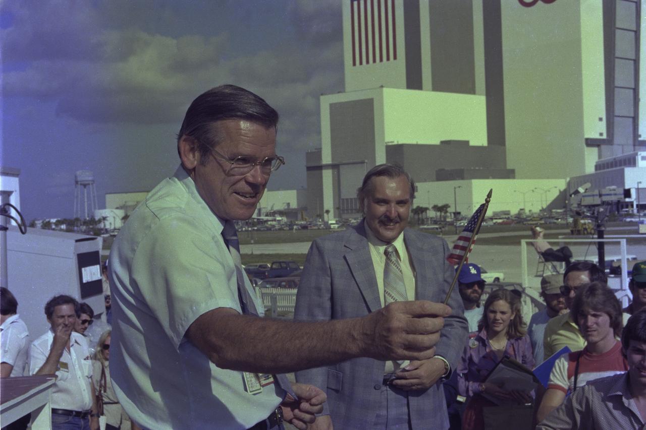 CAPE CANAVERAL, Fla. -- A smiling George Page, launch director for the historic maiden flight of space shuttle Columbia, waves a miniature American flag at the conclusion of a press conference following the successful launch on April 12.  With Page is Hugh Harris, chief of the Public Information Branch, NASA Public Affairs, Kennedy Space Center. Photo credit: NASA