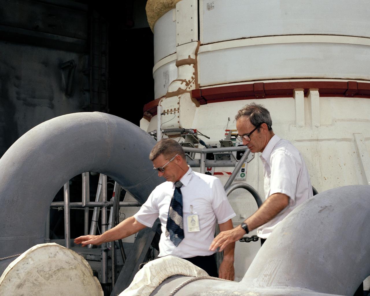 CAPE CANAVERAL, Fla. - Kennedy Space Center Director Lt. Gen. Forrest S. McCartney, left, stands on the fixed service structure in front of one of the space shuttle Atlantis' solid rocket boosters the morning after it is rolled out to Pad 39B. With McCartney is the pad site manager Bill Warren.    Photo credit: NASA