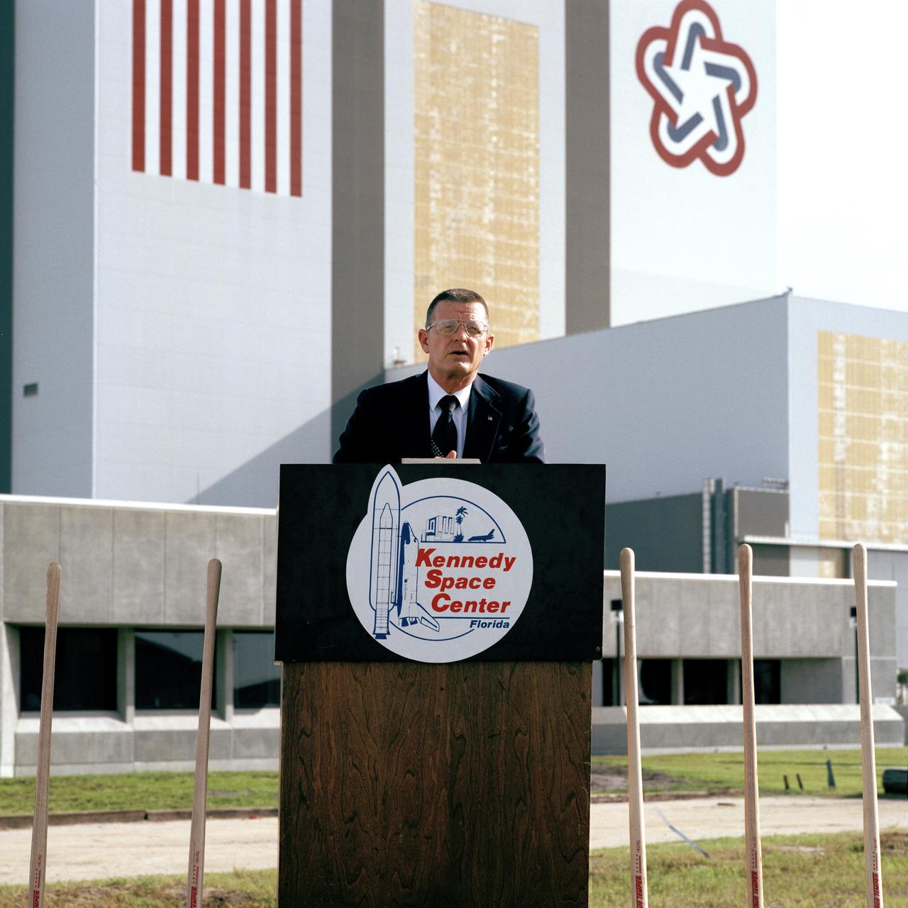 CAPE CANAVERAL, Fla. - Kennedy Space Center Director Forrest McCartney speaks at the ground-breaking ceremonies for the new Operations Support Building. This new facility will provide office accommodations for 1,700 NASA and contractor personnel. The $20,695,000, six-story, 300,000-square-foot building is located southwest of the Multi-Function Facility near the corner of the Saturn Causeway and Kennedy Parkway Roads. Construction is due to be completed by June 1990.    Photo credit: NASA