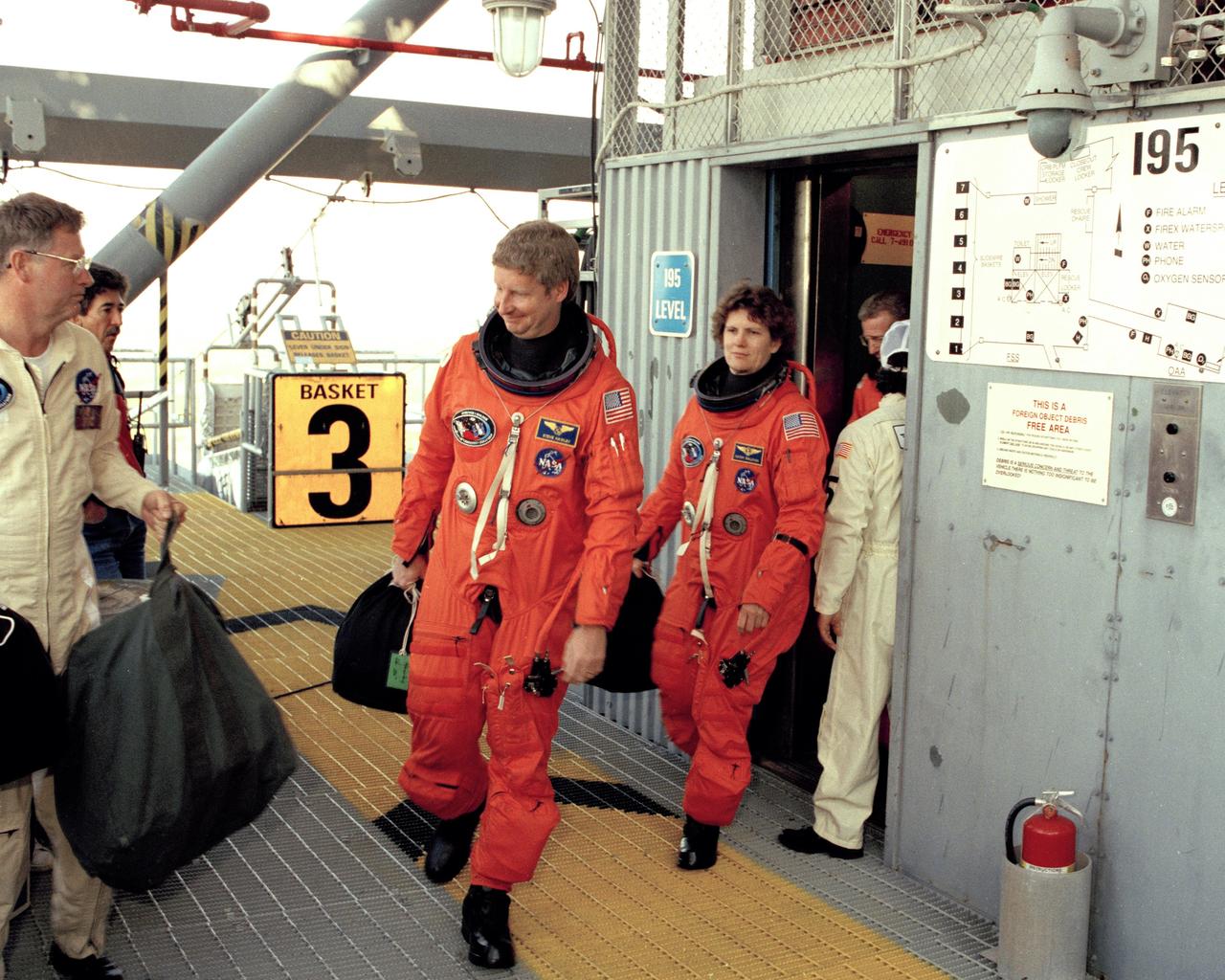 STS-31 Mission Specialists Steven A. Hawley (left) and Kathryn D. Sullivan, and Commander Loren J. Shriver prepare to enter the orbiter Discovery from the 195-foot level at Launch Pad 39B during the culmination of the two-day Terminal Countdown Demonstration Test (TCDT).  The TCDT, conducted March 19-20, is a dress rehearsal for launch, simulating final countdown from the T-24 hour mark up to T-5 seconds.  Space shuttle mission STS-31 is set to lift off on April 12, carrying a five-member crew and the Hubble Space Telescope. Photo credit: NASA