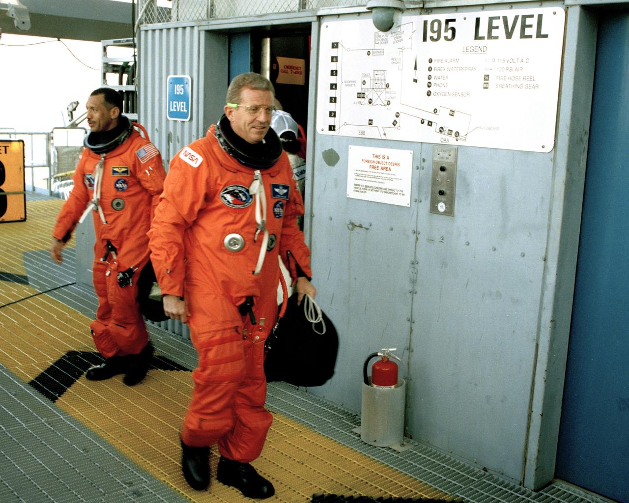 STS-31 Pilot Charles F. Bolden, left, and Commander Loren J. Shriver prepare to enter the orbiter Discovery from the 195-foot level at Launch Pad 39B during the culmination of the two-day Terminal Countdown Demonstration Test (TCDT). The TCDT, conducted March 19-20, is a dress rehearsal for launch, simulating final countdown from the T-24 hour mark up to T-5 seconds. Space shuttle mission STS-31 is set to lift off on April 12, carrying a five-member crew and the Hubble Space Telescope. Photo credit: NASA