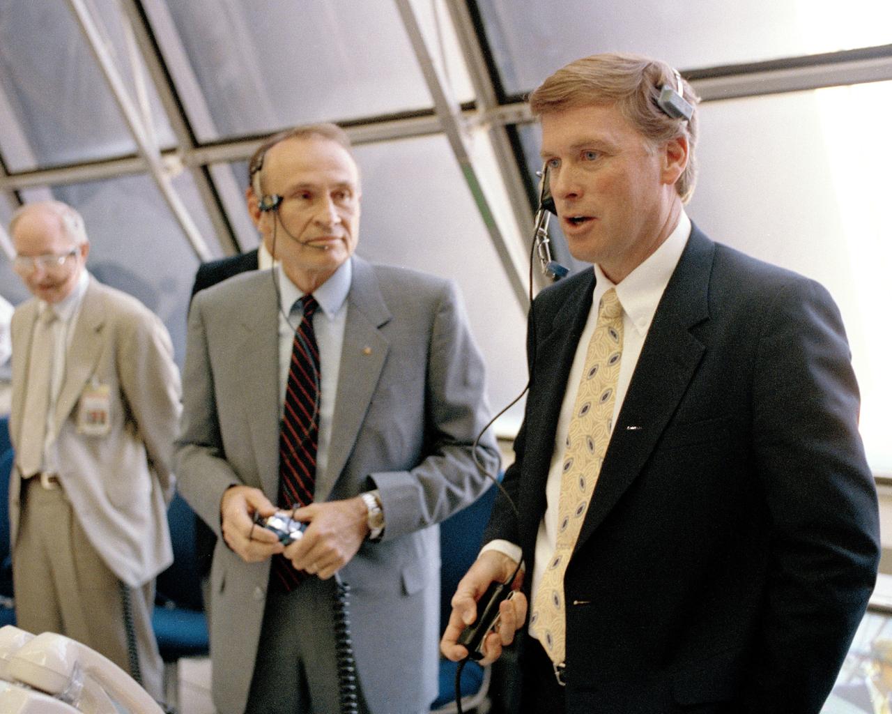CAPE CANAVERAL, Fla. -- Vice President of the United States Dan Quayle. right. tries on a communications headset in the Launch Control Center and learns about firing room activities from Launch Director Robert Sieck. Quayle spoke with members of the STS-39 flight crew participating in the Terminal Countdown Demonstration Test, toured the launch pad and other center facilities, addressed workers and held a press conference. Image credit: NASA