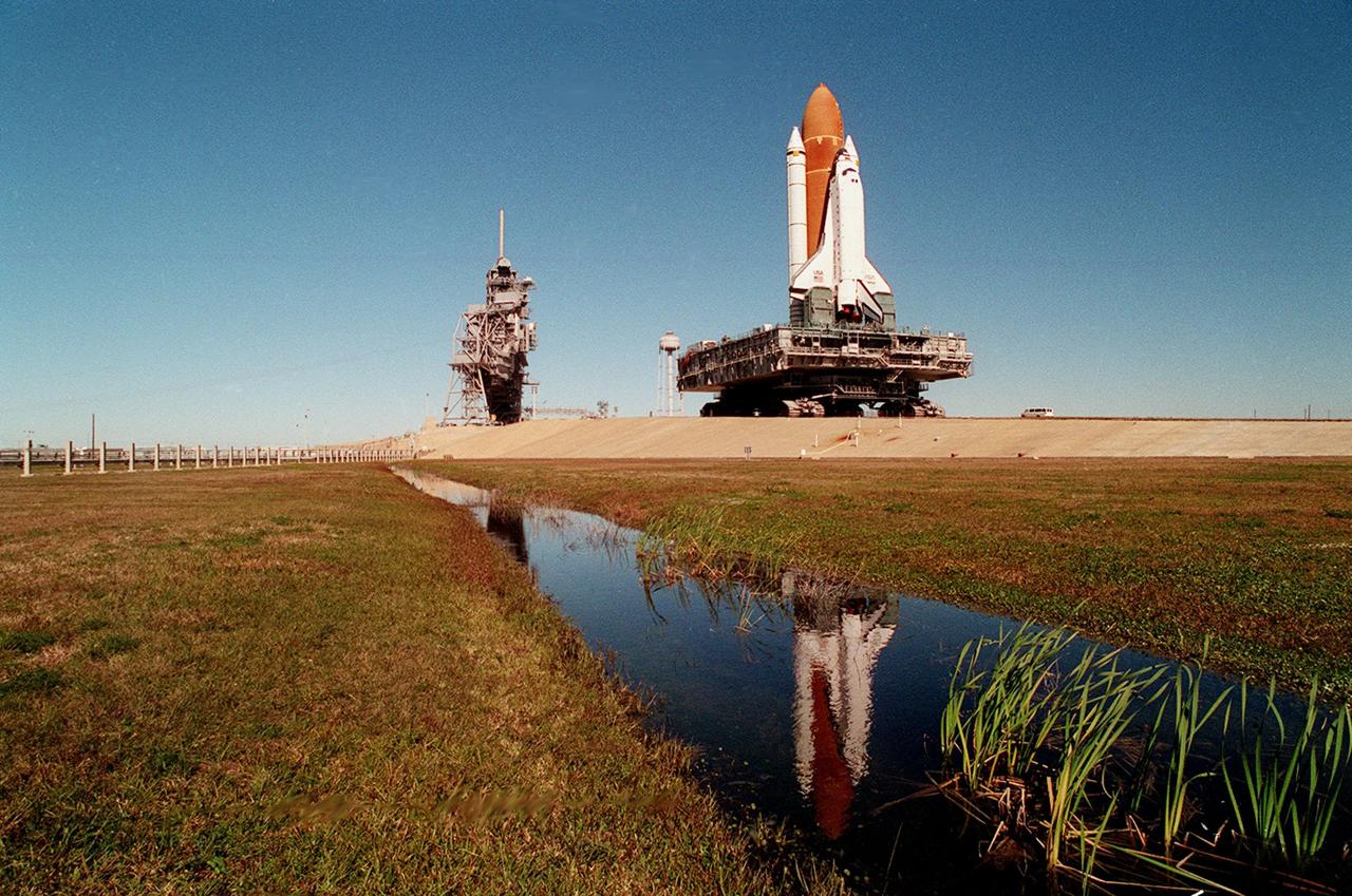 A massive 19 million pounds-plus (8.6 million kilograms) of Space Shuttle, support and transport hardware inch toward Launch Pad 39A from the Vehicle Assembly Building. The fully asssembled Space Shuttle Endeavour, minus its payloads, weighs about 4.5 million pounds (2 million kg.); the mobile launcher platform, on which it was assembled and from which it will lift off, weighs 9.25 million pounds (4.19 million kg.); and the crawler-transporter carrying the platform and Shuttle checks in at around 6 million pounds (2.7 million kg.). Once at the pad, the Shuttle and launch platform will be deposited atop support columns to complete preparations for the second Shuttle launch of 1995. The primary payload of mission STS-67 is the Astro-2 Astrophysics Observatory, carrying three ultraviolet telescopes that flew on the Astro-1 mission in 1990. STS-67 also is scheduled to become the longest shuttle flight to date, lasting 16 days