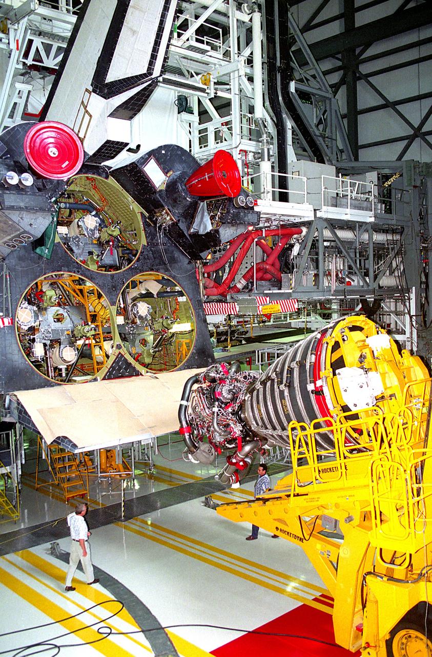 KENNEDY SPACE CENTER, FLA. -  A Space Shuttle Main Engine (SSME) hoist prepares to lift the first Block 1 engine to be installed in an orbiter into the number one position on Discovery while the spaceplane is being prepared for the STS-70 mission in the high bay of Orbiter Processing Facility 2.  The new engine, SSME No. 2036, features a new high-pressure liquid oxygen turbopump, a two-duct powerhead, a baffleless main injector, a single-coil heat exchanger and start sequence modifications.  The other two main engines to be used during the liftoff of the STS-70 mission are of the existing Phase II design.