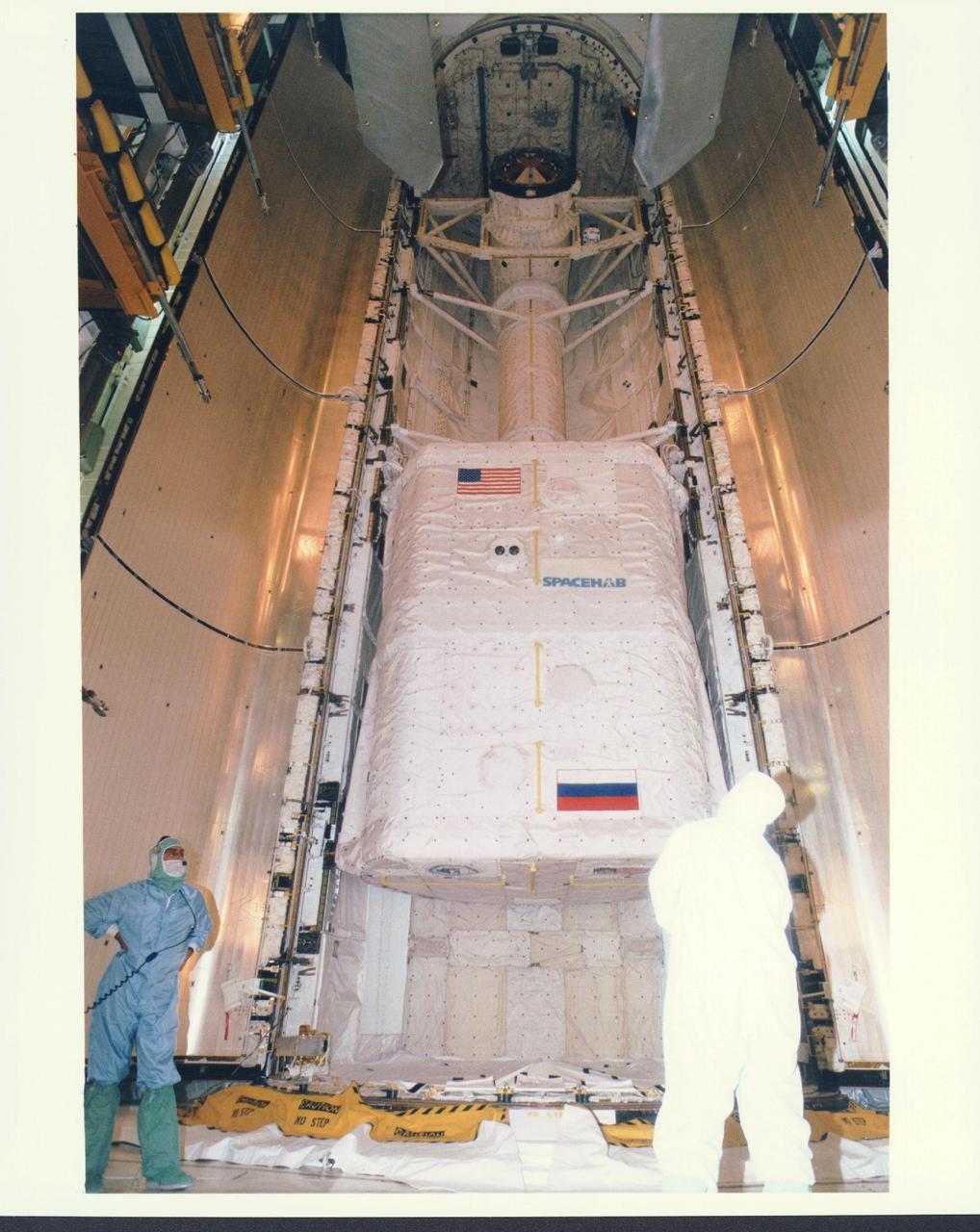 KENNEDY SPACE CENTER, FLA. -   Workers in the Payload Changeout Room (PCR) at Launch Pad 39A are preparing to close the payload doors for flight on the Space Shuttle Atlantis, targeted for liftoff on Mission STS-79 around Sept. 12.  The SPACEHAB Double Module located in the aft area of the payload bay is filled with supplies and other items slated for transfer to the Russian Space Station Mir. STS-79 marks the second flight of a SPACEHAB in support of the Shuttle-Mir dockings, and the first flight of the double-module configuration.  The SPACEHAB is connected by tunnel to the Orbiter Docking System (ODS), with the Androgynous Peripheral Docking System (APDS) clearly visible on top of the ODS. The APDS provides the docking interface for the linkup with Mir, while the ODS provides a passageway from the orbiter to the Russian space station and the SPACEHAB.