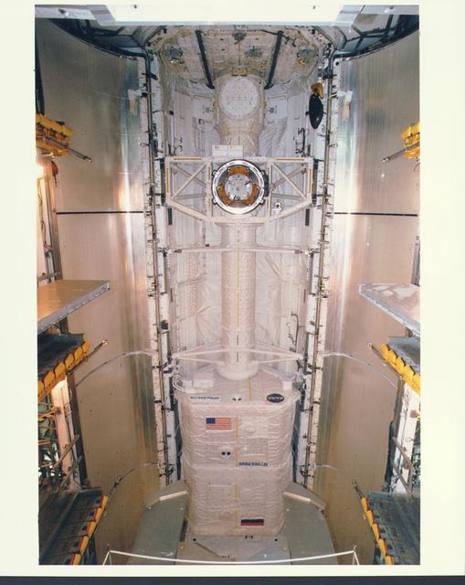 NASA image: KENNEDY SPACE CENTER, FLA. -   Workers in the Payload Changeout Room (PCR) at Launch Pad 39A are preparing to close the payload doors for flight on the Space Shuttle Atlantis, targeted for liftoff on Mission STS-79 around Sept. 12.  The payloads in Atlantis' cargo bay will play key roles during the upcoming spaceflight, which will be highlighted by the fourth docking between the U.S. Shuttle and Russian Space Station Mir.  Located in the aft (lowermost) area of the payload bay is the SPACEHAB Double Module, filled with supplies and other items slated for transfer to the Russian Space Station Mir as well as research equipment.  The SPACEHAB is connected by tunnel to the Orbiter Docking System (ODS).  This view looks directly at the top of the ODS and shows clearly the Androgynous Peripheral Docking System (APDS) that interfaces with the Docking Module on Mir to achieve a linkup.