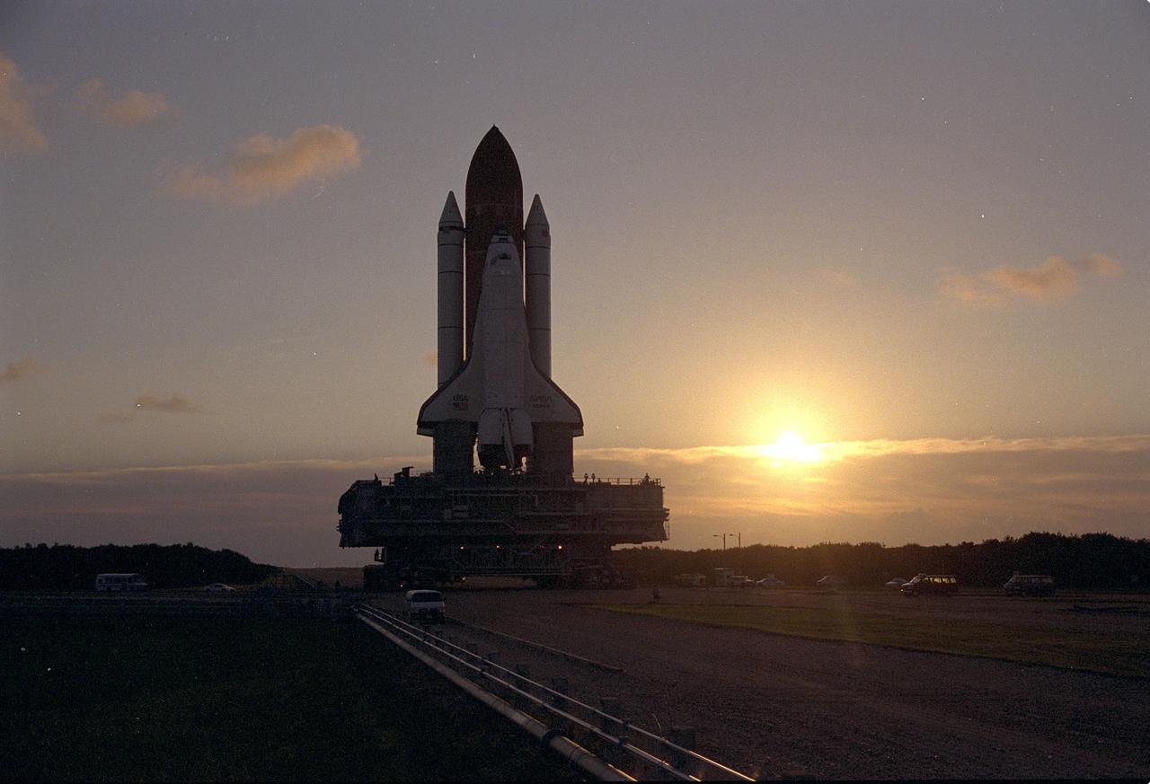 KENNEDY SPACE CENTER, FLA. - As the sun begins to rise in the early-morning sky after its departure from Launch Pad 39A, the Space Shuttle Atlantis slowly travels on the crawlerway toward the Vehicle Assembly Building. This marks the second rollback for Atlantis since July because of hurricane threats. Atlantis, which is targeted fo liftoff later this month on the STS-79 Shuttle mission, is returning to the VAB because of the threat from Hurricane Fran. The threat of Hurricane Bertha forced the rollback of Atlantis in July. Atlantis currently is scheduled for launch on the fourth Shuttle-Mir docking mission around mid-September.