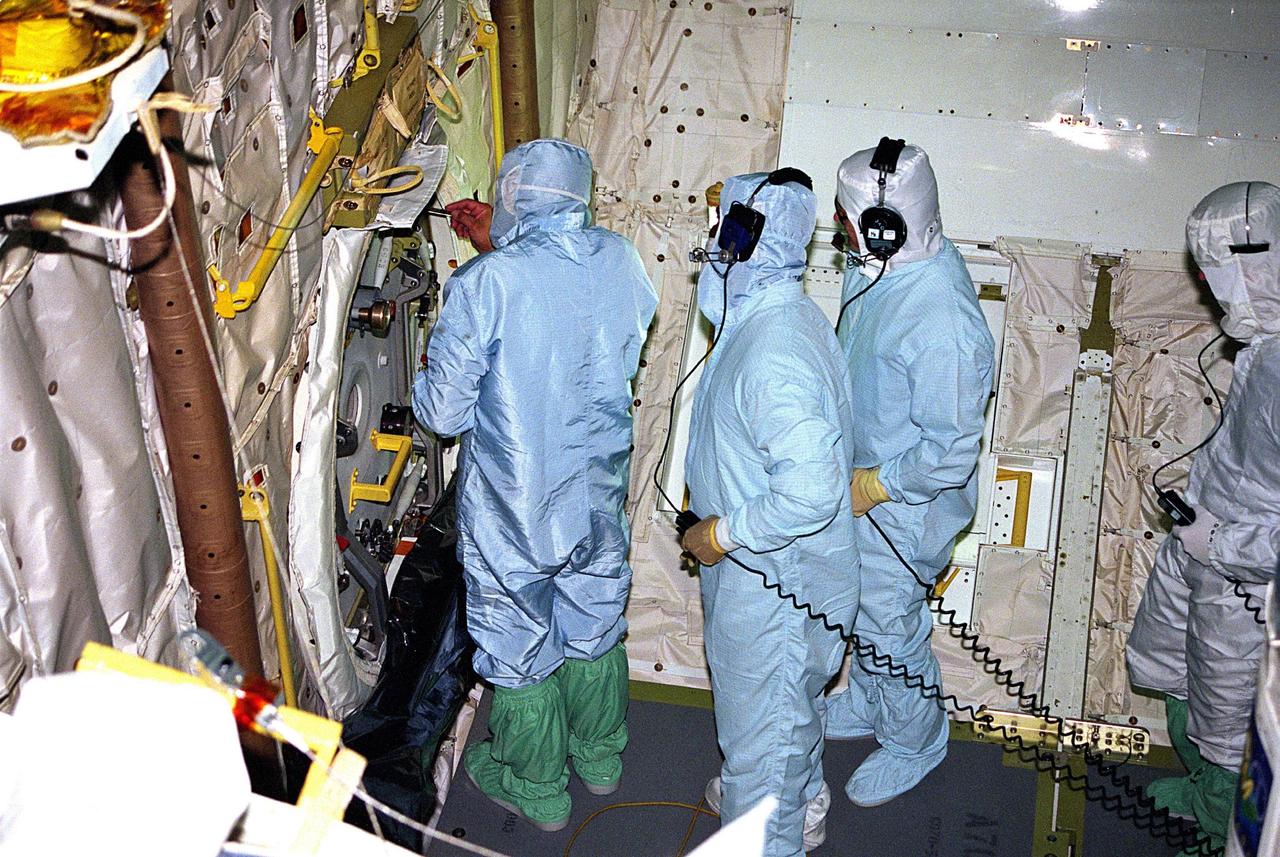 KENNEDY SPACE CENTER, FLA. -- United Space Alliance (USA) technicians in Orbiter Processing Facility Bay 1 troubleshoot the orbiter Columbia’s outer hatch of the airlock, which failed to open during the recent STS-80 Space Shuttle mission. Mission Specialists Tamara E. Jernigan and Thomas D. Jones did not perform the mission’s planned two extravehicular activities (EVAs) or spacewalks because the hatch would not open on orbit. The spacewalks were to be part of the continuing series of EVA Development Flight Tests to evaluate equipment and procedures and to build spacewalking experience in preparation for the International Space Station.