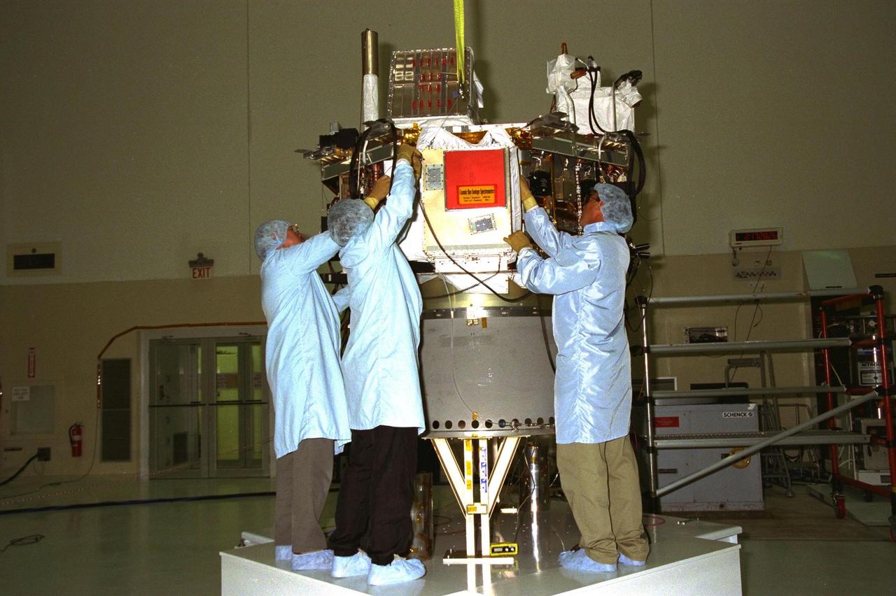 Workers from the Johns Hopkins University’s Applied Physics Laboratory (APL) install the Cosmic Ray Isotope Spectrometer (CRIS) on the Advanced Composition Explorer (ACE) spacecraft in KSC’s Spacecraft Assembly and Encapsulation Facility-2 (SAEF-2). From left, are Al Sadilek, Marcos Gonzalez and Cliff Willey. CRIS is one of nine instruments on ACE, which will investigate the origin and evolution of solar phenomenon, the formation of the solar corona, solar flares and the acceleration of the solar wind. ACE was developed for NASA by the APL. The spacecraft is scheduled to be launched Aug. 21 aboard a two-stage Delta II 7920-8 rocket from Space Launch Complex 17, Pad A