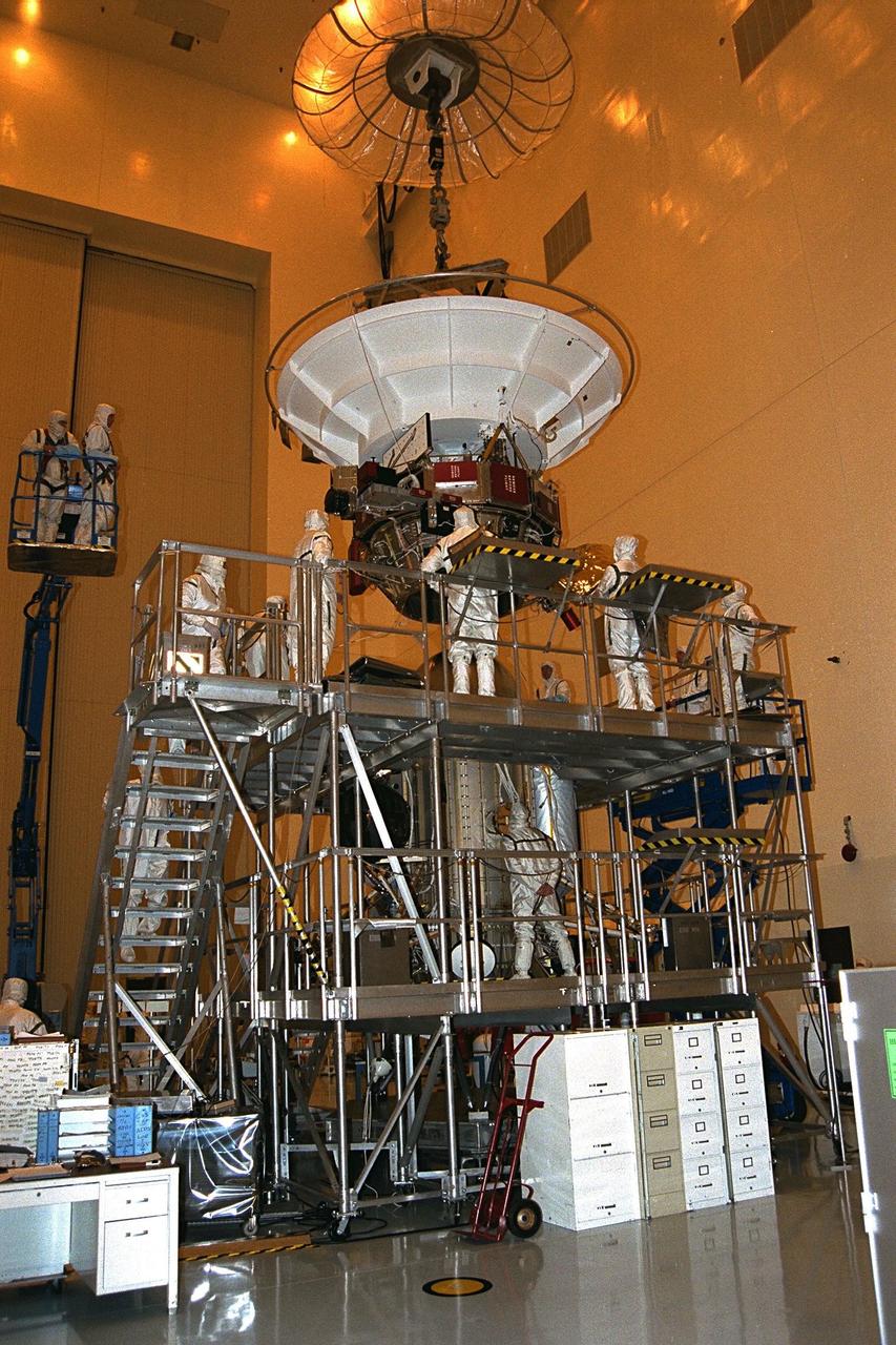 Technicians from the Jet Propulsion Laboratory (JPL)  attach the upper equipment module to the propulsion module and the lower equipment  module in the Payload Hazardous Servicing Facility in July prior to installation on the Cassini spacecraft at KSC. A four-year, close-up study of the Saturnian system, the  mission is scheduled for launch from Cape Canaveral Air Station in October 1997. It will  take seven years for the spacecraft to reach Saturn. JPL is managing the Cassini project  for NASA
