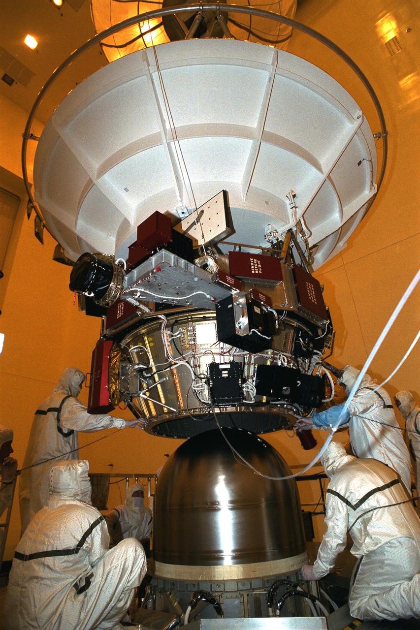 Technicians from the Jet Propulsion Laboratory (JPL)  lower the upper equipment module over a propellant tank in the Payload Hazardous  Servicing Facility at KSC in July prior to installation on the Cassini orbiter. A four-year,  close-up study of the Saturnian system, the Cassini mission is scheduled for launch from  Cape Canaveral Air Station in October 1997. The propellant tank will assist with  guidance of the orbiter and power during the spacecraft’s voyage and in-orbit periods. It  will take seven years for the spacecraft to reach Saturn. Scientific instruments carried  aboard the spacecraft will study Saturn’s atmosphere, magnetic field, rings, and several  moons. JPL is managing the Cassini project for NASA