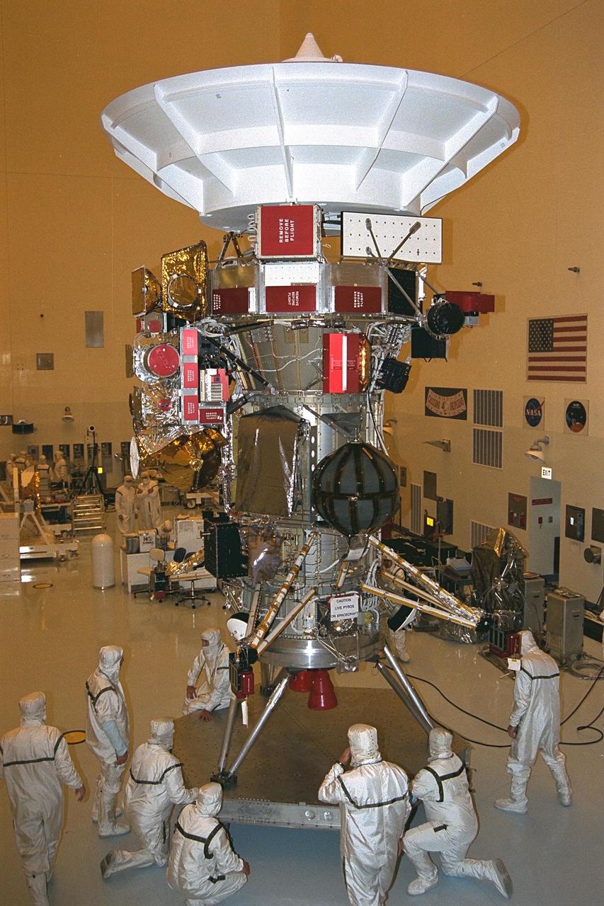 Jet Propulsion Laboratory (JPL) technicians reposition and  level the Cassini orbiter in the Payload Hazardous Servicing Facility at KSC in July after  stacking the craft’s upper equipment module on the propulsion module. A four-year,  close-up study of the Saturnian system, the Cassini mission is scheduled for launch from  Cape Canaveral Air Station in October 1997. It will take seven years for the spacecraft to  reach Saturn. Scientific instruments carried aboard the spacecraft will study Saturn’s  atmosphere, magnetic field, rings, and several moons. JPL is managing the Cassini  project for NASA