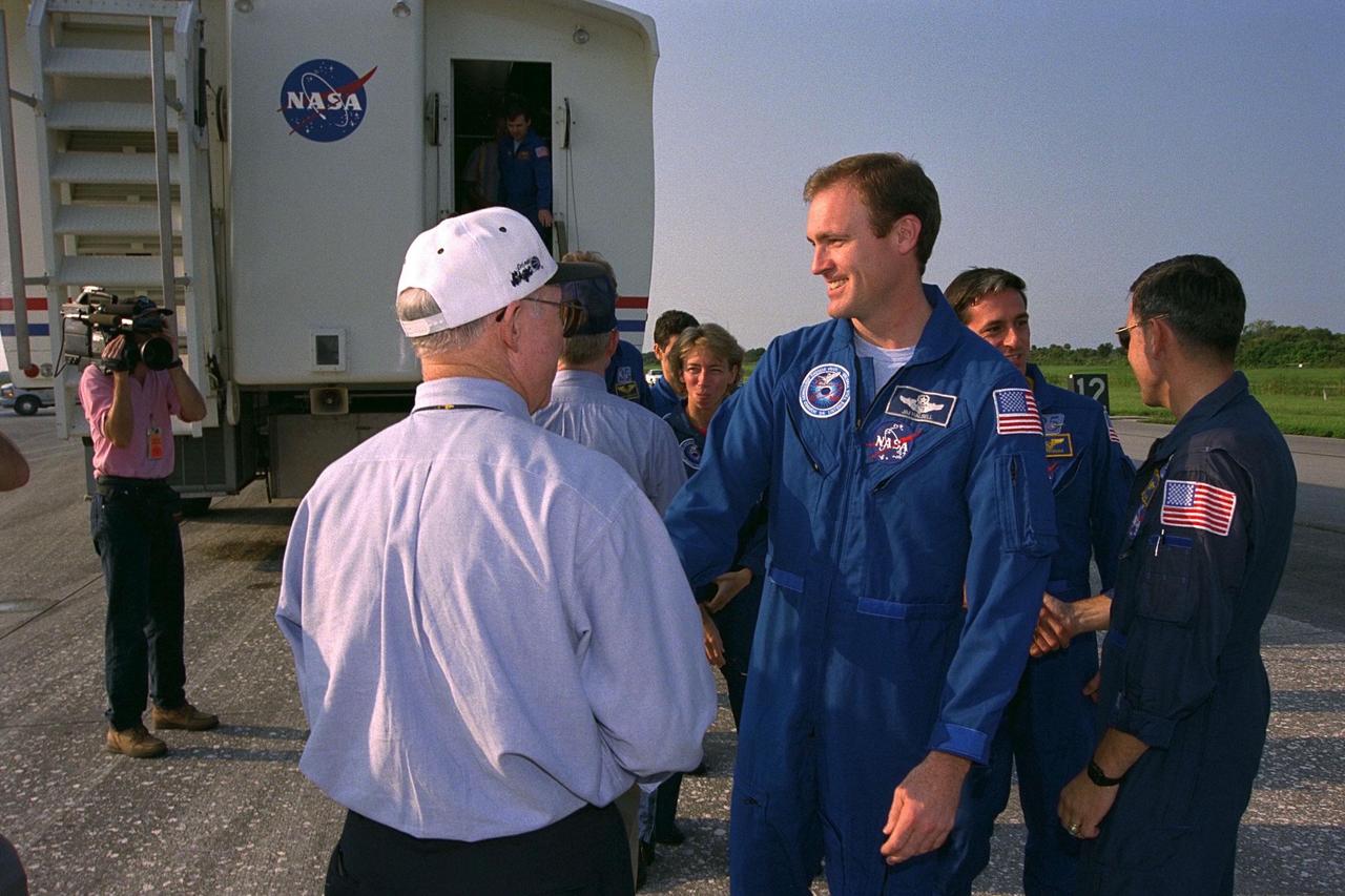 STS-94 Mission Commander James D. Halsell  Jr. (center) shakes hands with KSC Shuttle Launch Director James F. Harrington (in  white cap) after an end-of-mission landing on Runway 33 of KSC’s Shuttle Landing  Facility July 17 to complete the Microgravity Science Laboratory-1 (MSL-1) mission.  Main gear touchdown occurred at 6:46:34 a.m. EDT, July 17. At right, STS-88 Mission  Commander and Shuttle Training Aircraft (STA) pilot Robert D. Cabana greets STS-94  Mission Specialist Donald A. Thomas. In the background, KSC Center Director Roy D.  Bridges Jr. meets with other members of the STS-94 crew