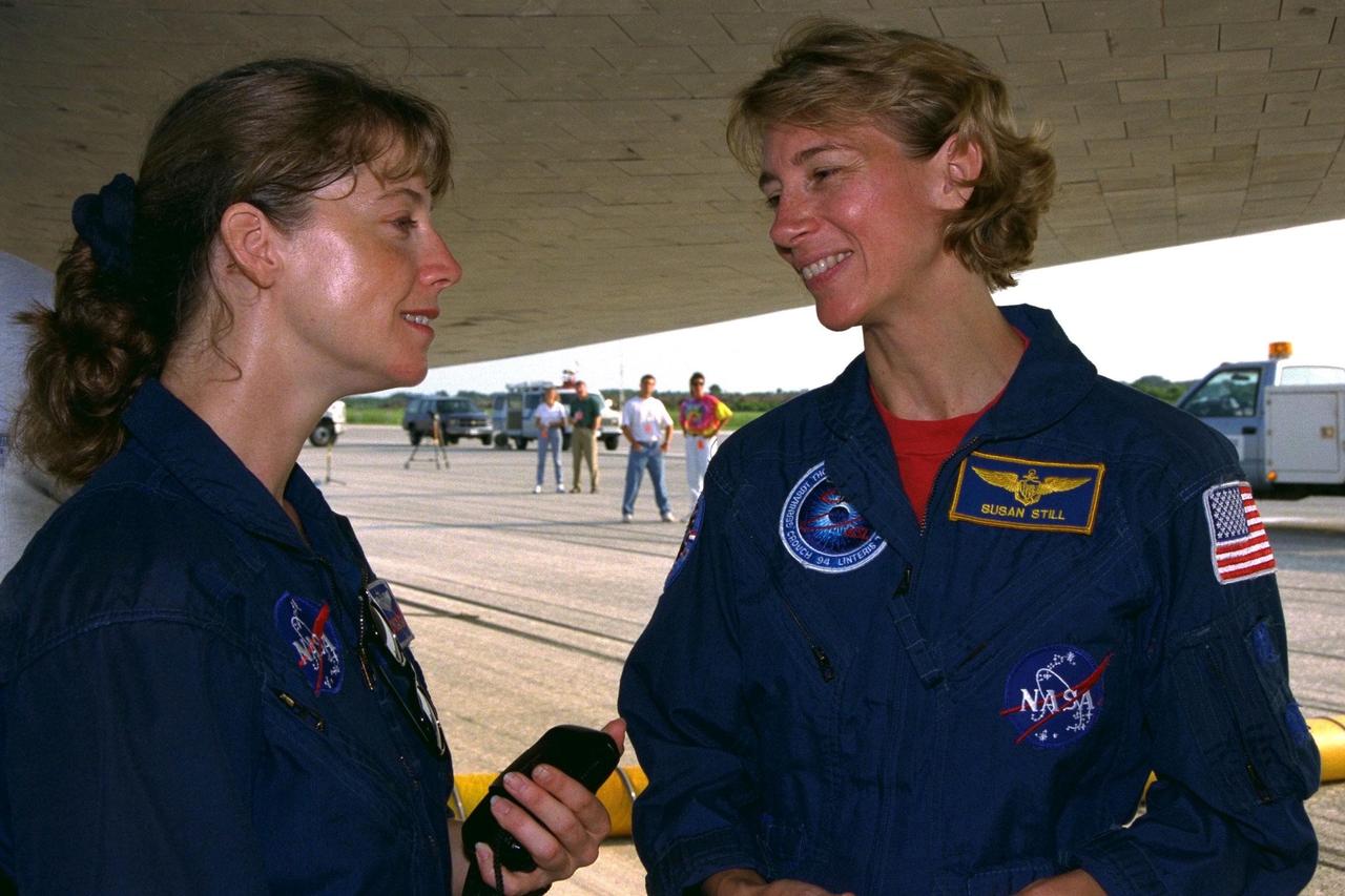 KENNEDY SPACE CENTER, FLA. -- Astronaut Support team member Pamela A.  Melroy (left) greets STS-94 Pilot Susan L. Still underneath the Space Shuttle orbiter  Columbia after an end-of-mission landing on Runway 33 of KSC’s Shuttle Landing  Facility July 17 to complete the Microgravity Science Laboratory-1 (MSL-1) mission. Six  of the seven STS-94 crew members took the traditional post-landing walk around the  orbiter, meeting with members of the orbiter recovery convoy team and inspecting the  vehicle that carried them through space for nearly 17 days on a highly successful  microgravity research mission
