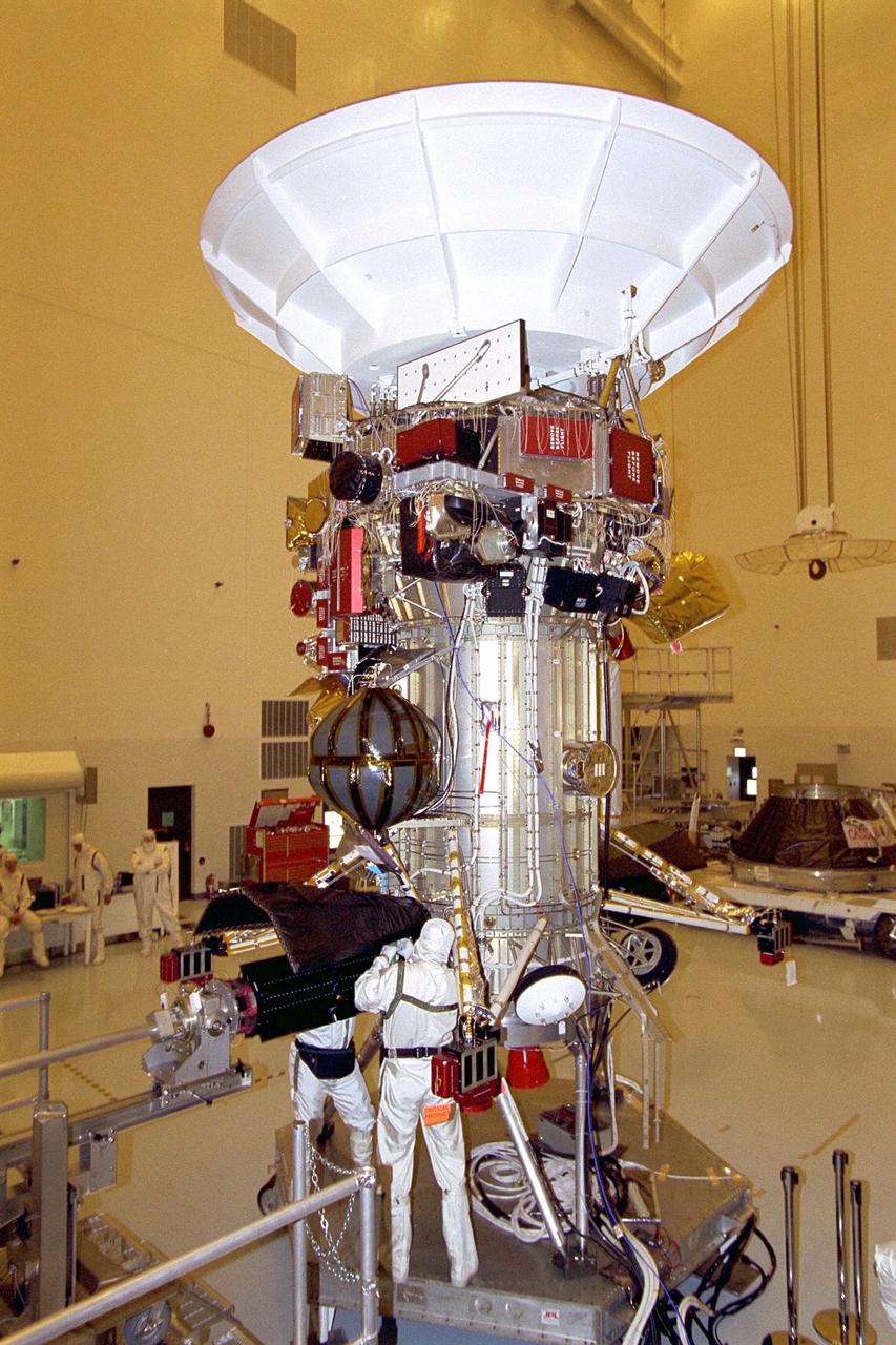 Jet Propulsion Laboratory (JPL) workers Dan  Maynard and John Shuping prepare to install a radioisotope thermoelectric generator  (RTG) on the Cassini spacecraft in the Payload Hazardous Servicing Facility (PHSF).  The three RTGs which will provide electrical power to Cassini on its mission to the  Saturnian system are undergoing mechanical and electrical verification testing in the  PHSF. RTGs use heat from the natural decay of plutonium to generate electric power.  The generators enable spacecraft to operate far from the Sun where solar power  systems are not feasible. The Cassini mission is scheduled for an Oct. 6 launch aboard  a Titan IVB/Centaur expendable launch vehicle. Cassini is built and managed for NASA  by JPL