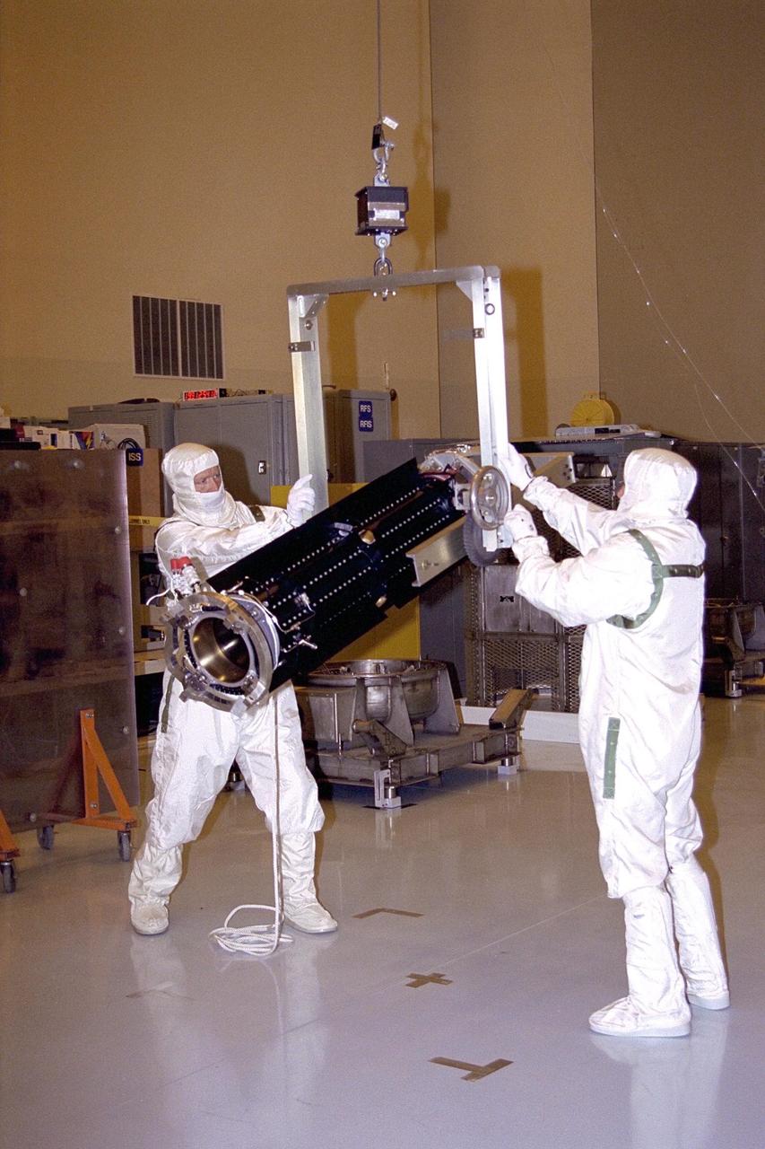 Jet Propulsion Laboratory (JPL) workers David Rice,  at left, and Johnny Melendez rotate a radioisotope thermoelectric generator (RTG) to  the horizontal position on a lift fixture in the Payload Hazardous Servicing Facility. The  RTG is one of three generators which will provide electrical power for the Cassini  spacecraft mission to the Saturnian system. The RTGs will be installed on the  powered-up spacecraft for mechanical and electrical verification testing. RTGs use heat  from the natural decay of plutonium to generate electric power. The generators enable  spacecraft to operate far from the Sun where solar power systems are not feasible. The  Cassini mission is scheduled for an Oct. 6 launch aboard a Titan IVB/Centaur  expendable launch vehicle. Cassini is built and managed for NASA by JPL