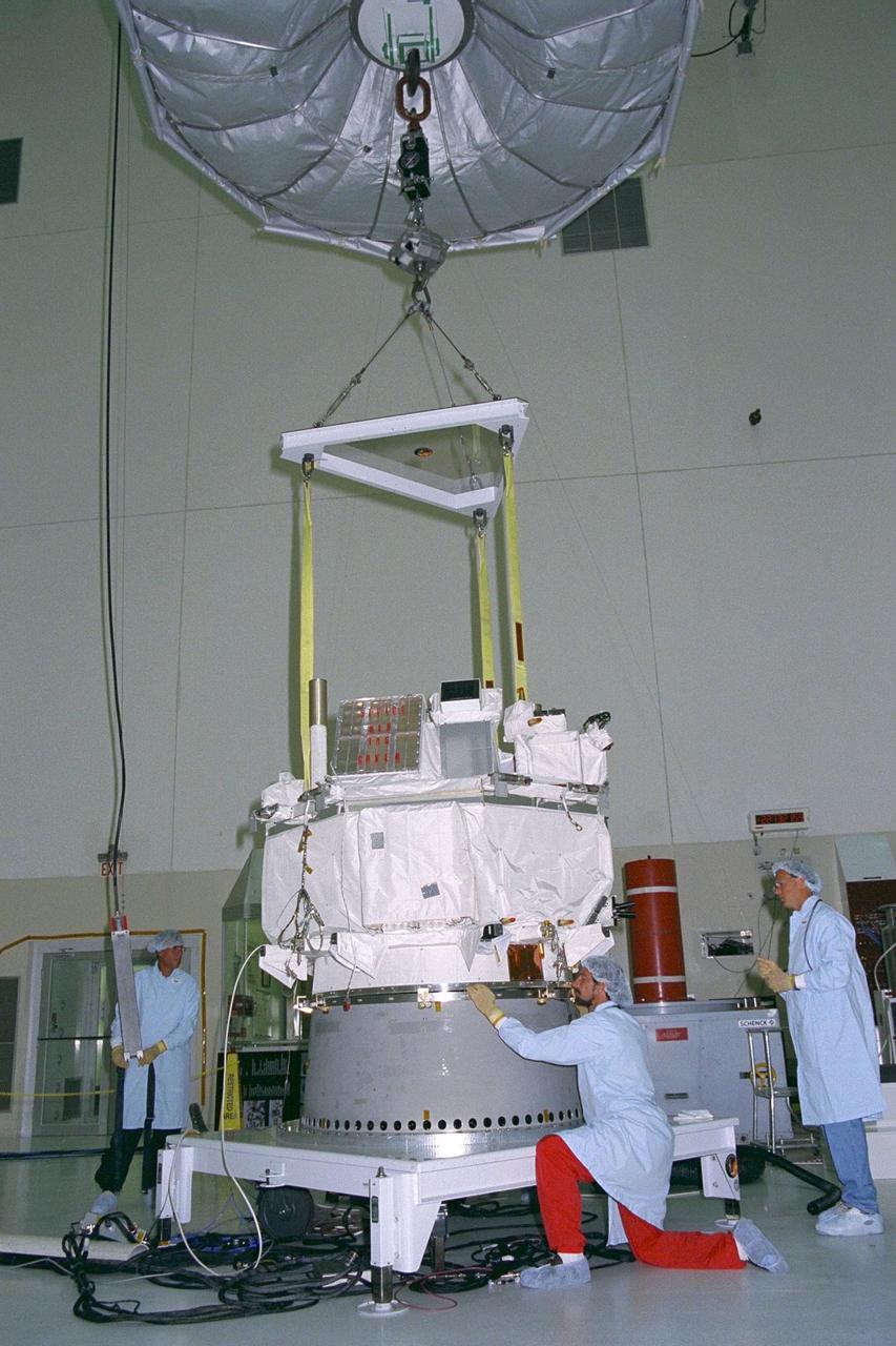 Applied Physics Laboratory engineers and technicians from Johns Hopkins University assist in leveling and orienting the Advanced Composition Explorer (ACE) as it is seated on a platform for solar array installation in KSC’s Spacecraft Assembly and Encapsulation Facility-II. Scheduled for launch on a Delta II rocket from Cape Canaveral Air Station on Aug. 25, ACE will study low-energy particles of solar origin and high-energy galactic particles. The ACE observatory has six high-resolution particle detection sensors and three monitoring instruments. The collecting power of instrumentation aboard ACE is at least 100 times more sensitive than anything previously flown to collect similar data by NASA
